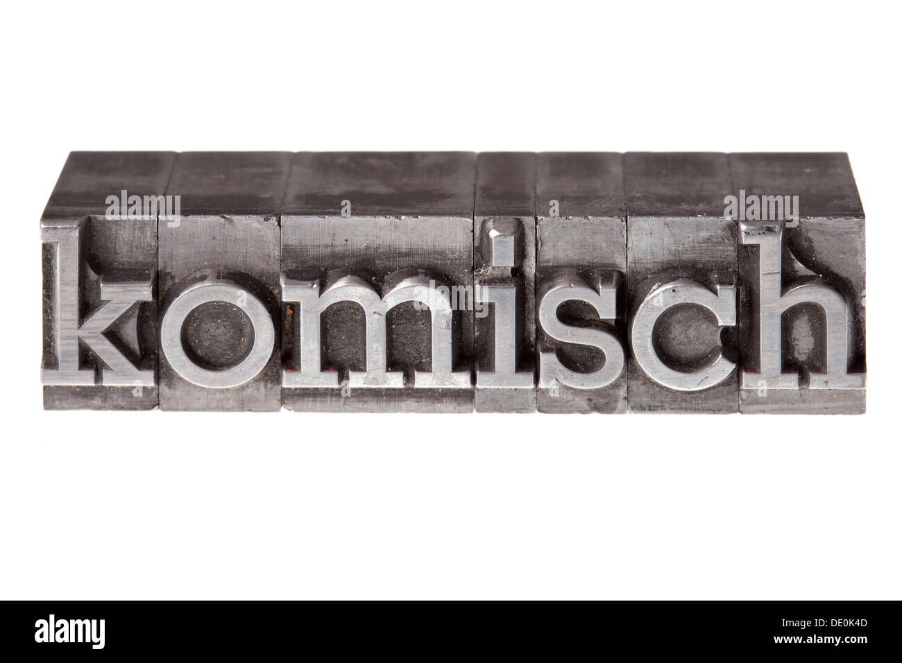 Antiguas letras de plomo que forman la palabra "komisch', Alemán para extraño o extraño Foto de stock