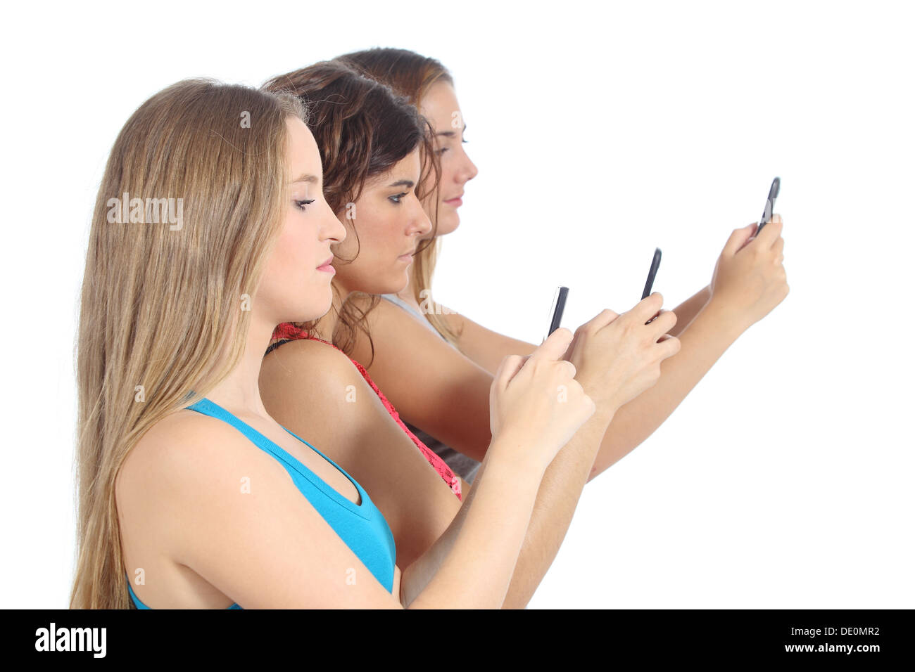 Un grupo de niñas adolescentes obsesionados con el teléfono inteligente aislado sobre un fondo blanco. Foto de stock