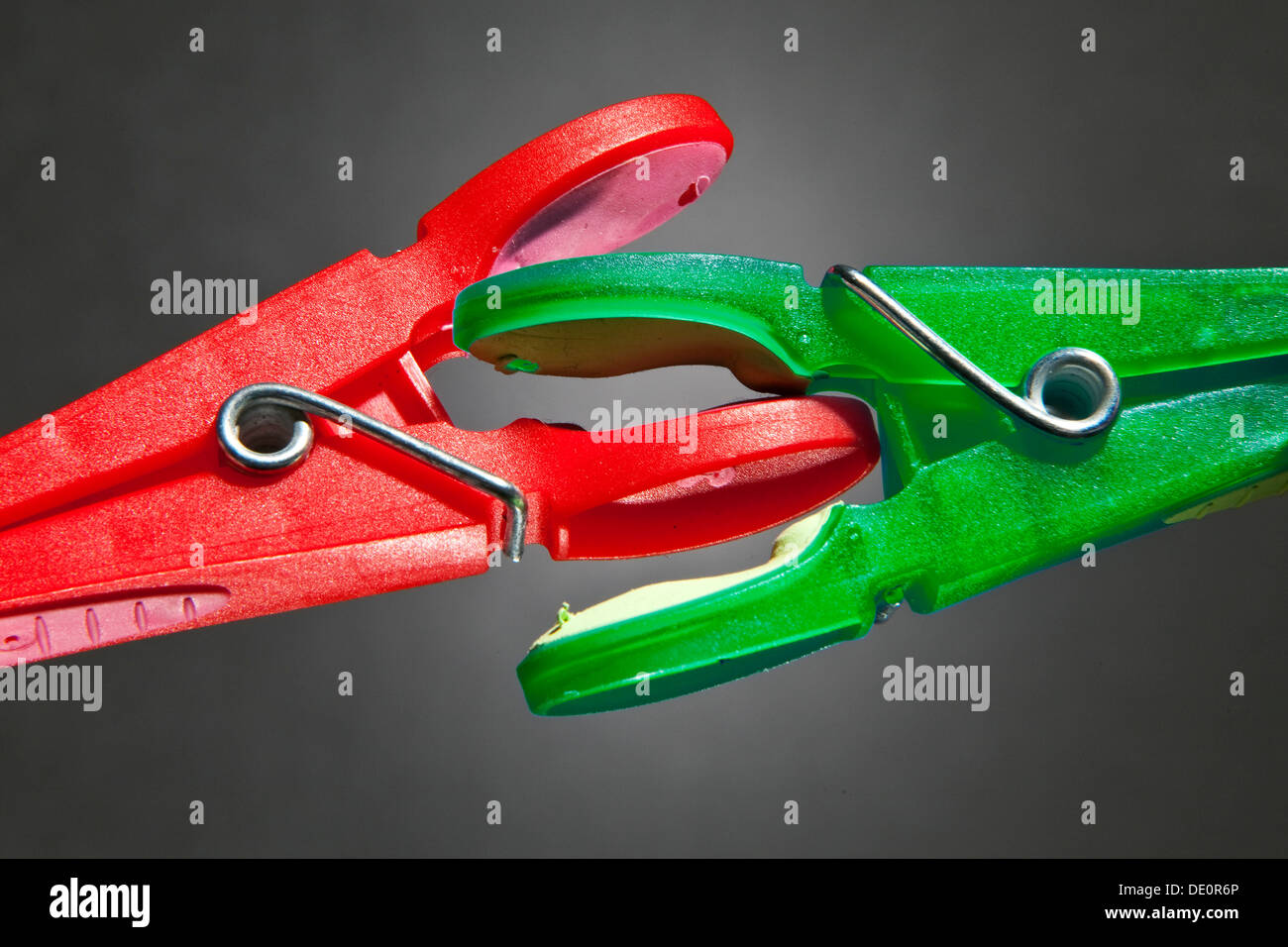 Una pinza roja y verde-peg ropa luchan el uno con el otro, imagen simbólica de las luchas por el poder político Foto de stock