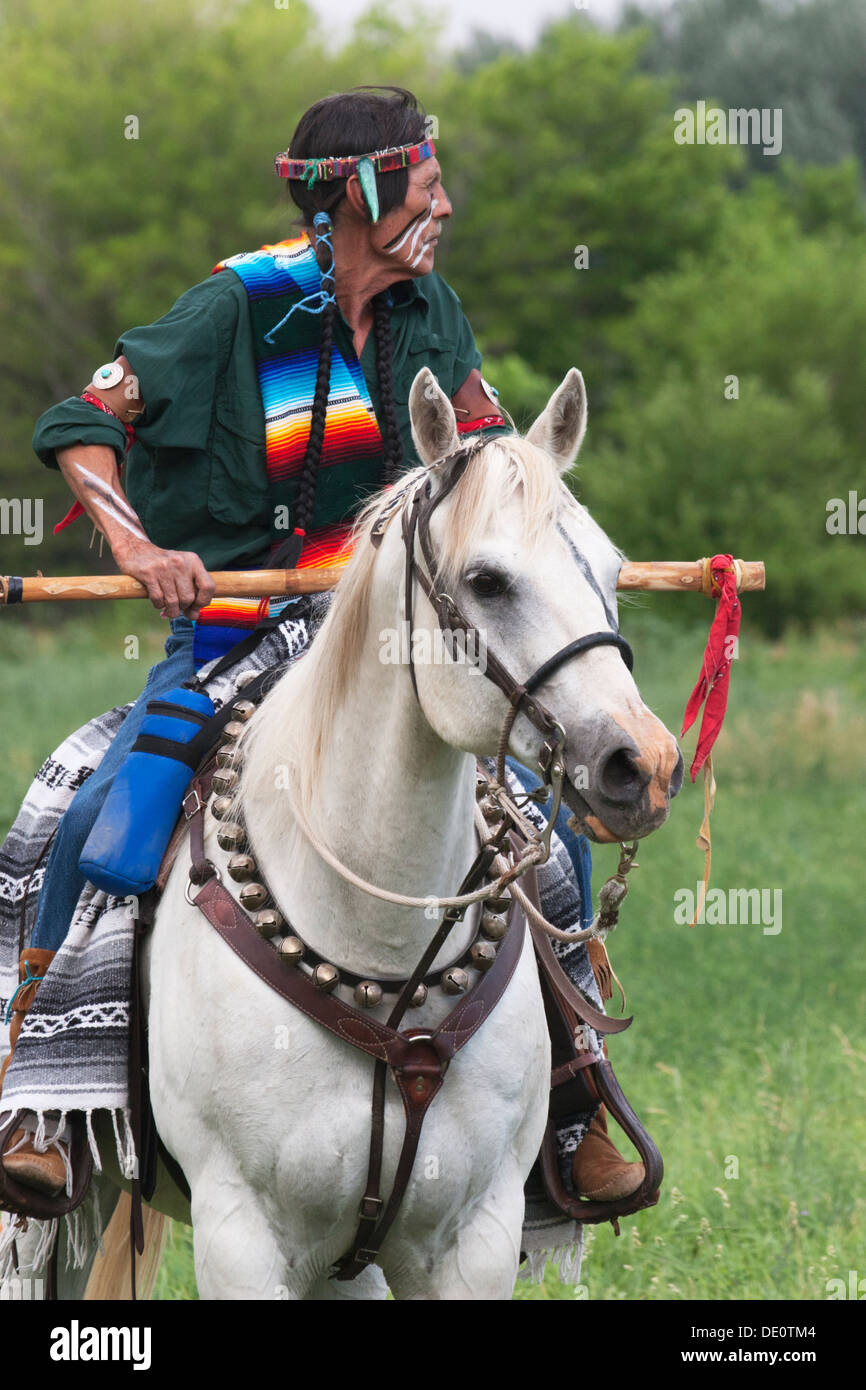 Guerrero en Comanche vestido montando caballo blanco Foto de stock