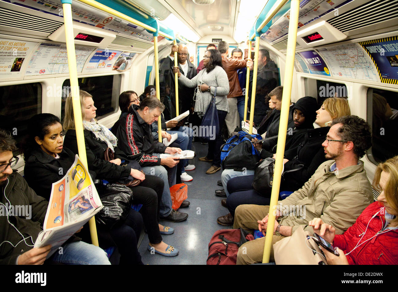 Los pasajeros de pie en un concurrido tren subterráneo de Londres, Londres, Reino Unido Foto de stock