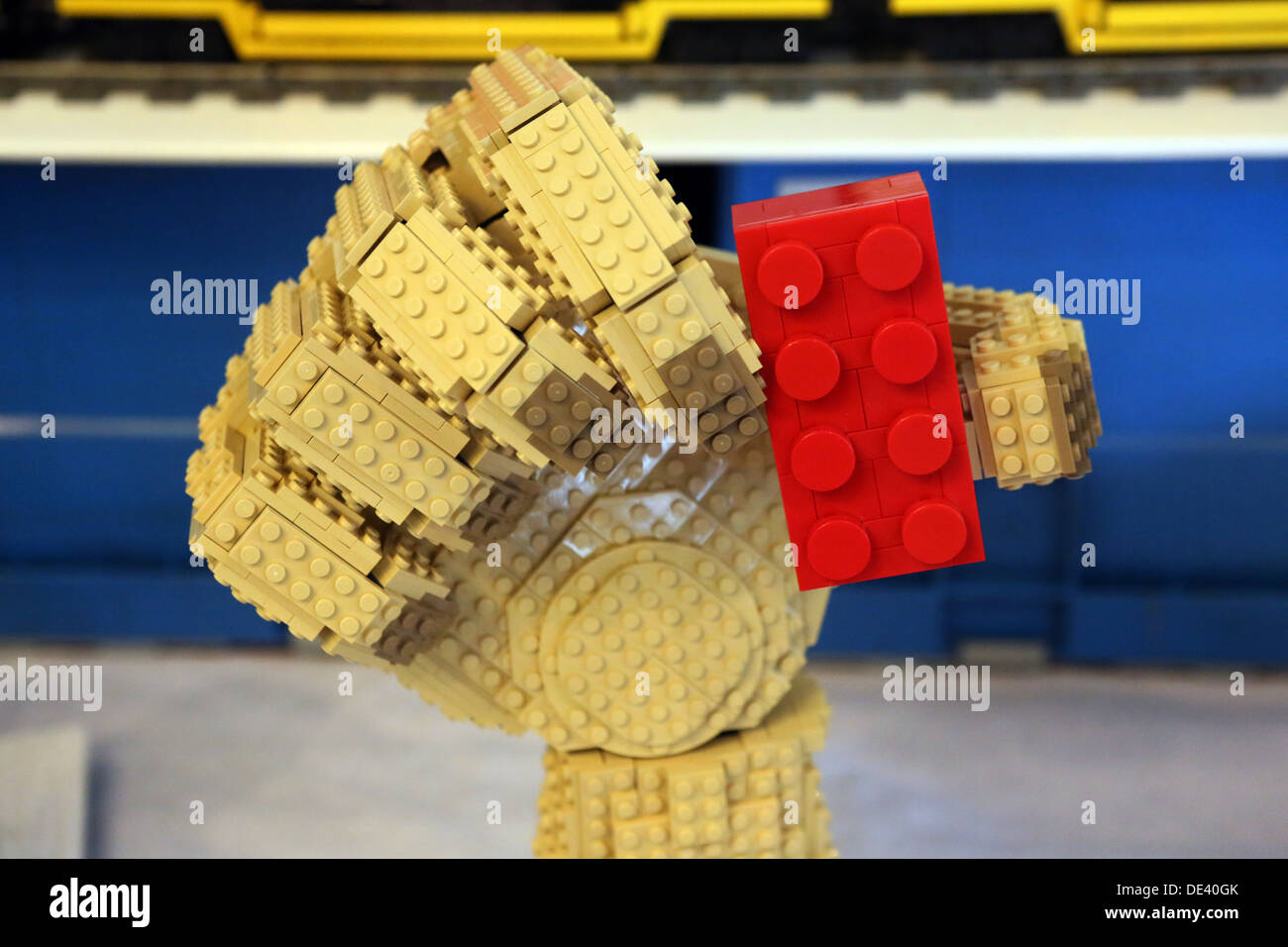 Berlín, Alemania, la mano sujeta firmemente un edificio de ladrillos de Lego Lego Foto de stock