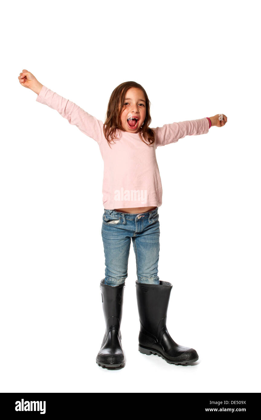 Niña de siete años con demasiado grandes botas de goma Foto de stock