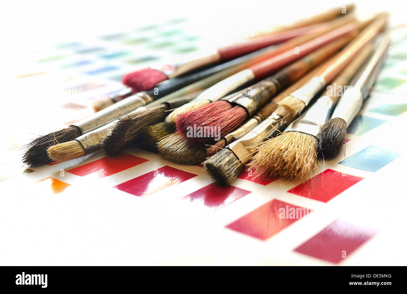 Pinceles de artista en un muestrario de colores Foto de stock