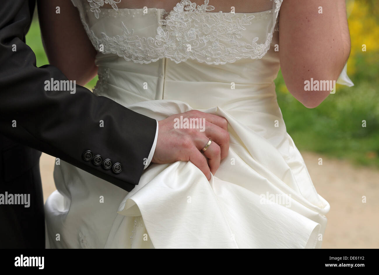 Buckow, Alemania, el novio mantiene firmemente a su esposa 's vestido de novia Foto de stock
