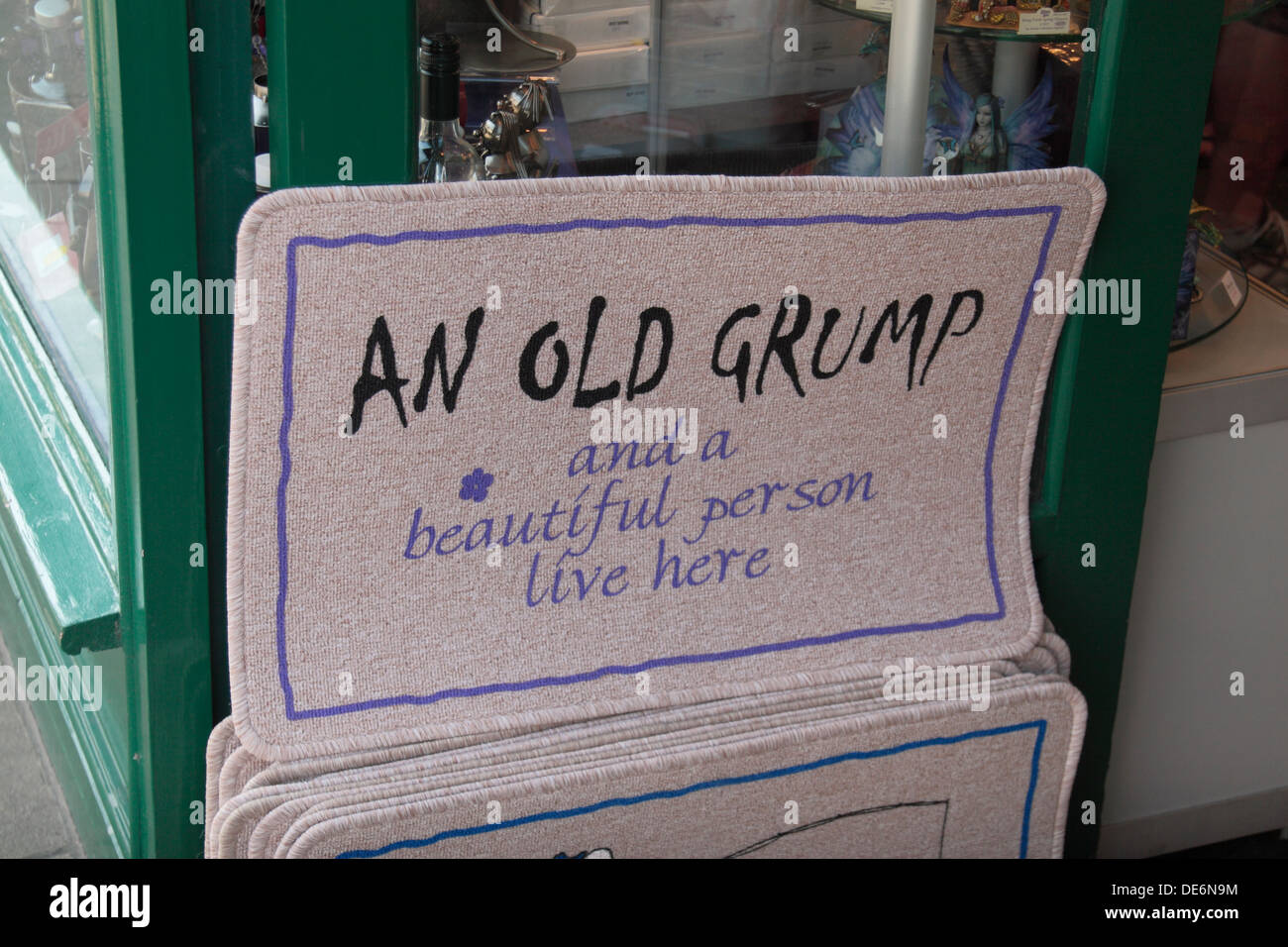 Puerta delantera divertida alfombrilla para la venta fuera de una tienda en Lyndhurst, New Forest, Reino Unido. "Un viejo Grump y una bella persona vivir aquí". Foto de stock