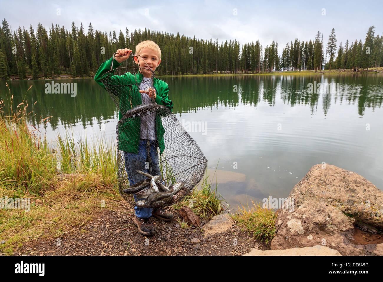 Joven mostrando la trucha que ha pescado en el lago Eggleston, Grand Mesa National Forest, Colorado, EE.UU. Foto de stock