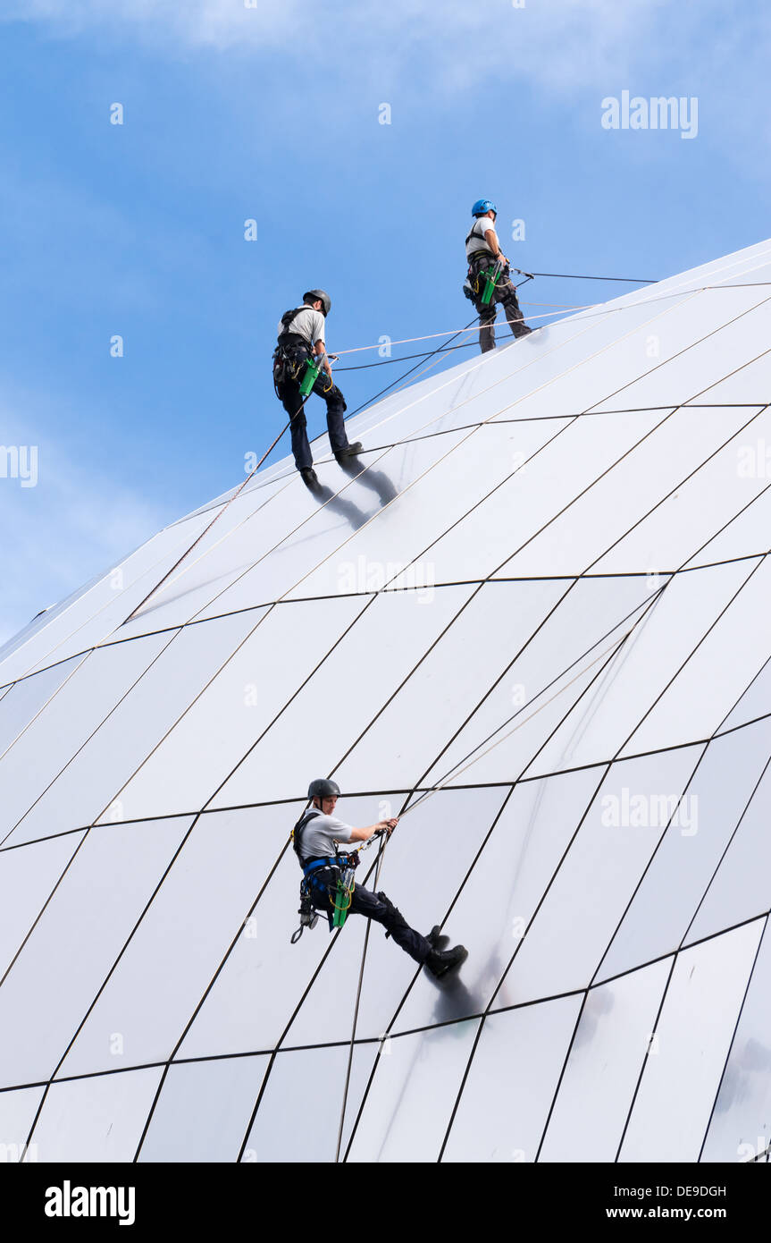 Tres hombres rappel abajo el techo curvo de la Sage Gateshead Concert Hall, al noreste de Inglaterra, Reino Unido. Foto de stock
