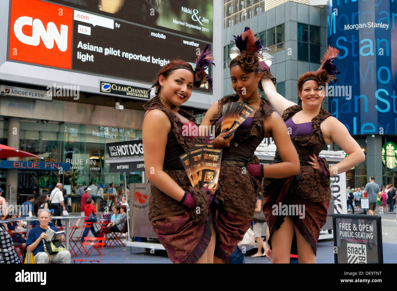 New York, NY - 11 de julio de 2013: tres mujeres vestidas en trajes vintage sosteniendo carteles plantean Times Square. Foto de stock
