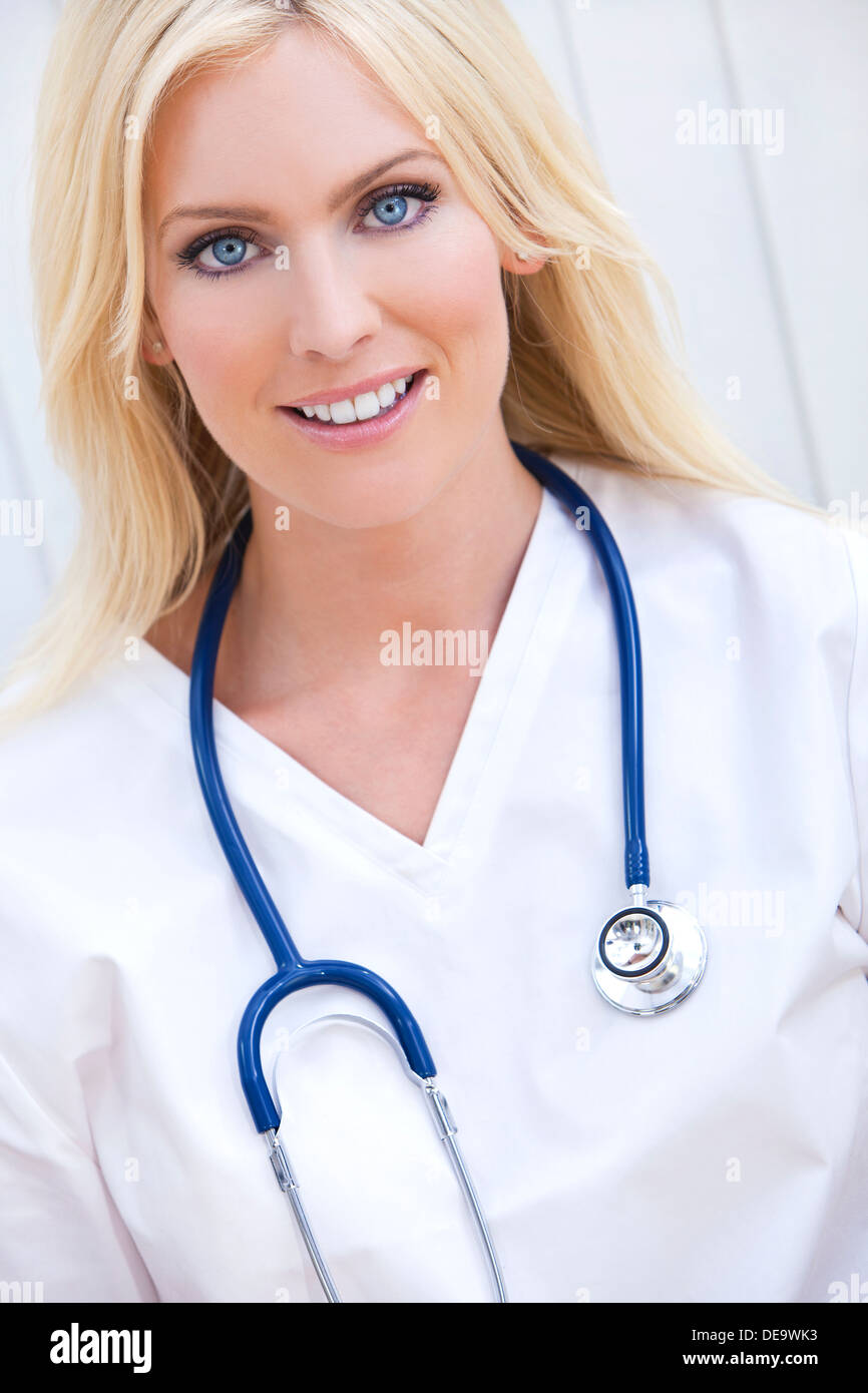 Feliz y sonriente, hembra hospital médico o enfermera con estetoscopio Foto de stock