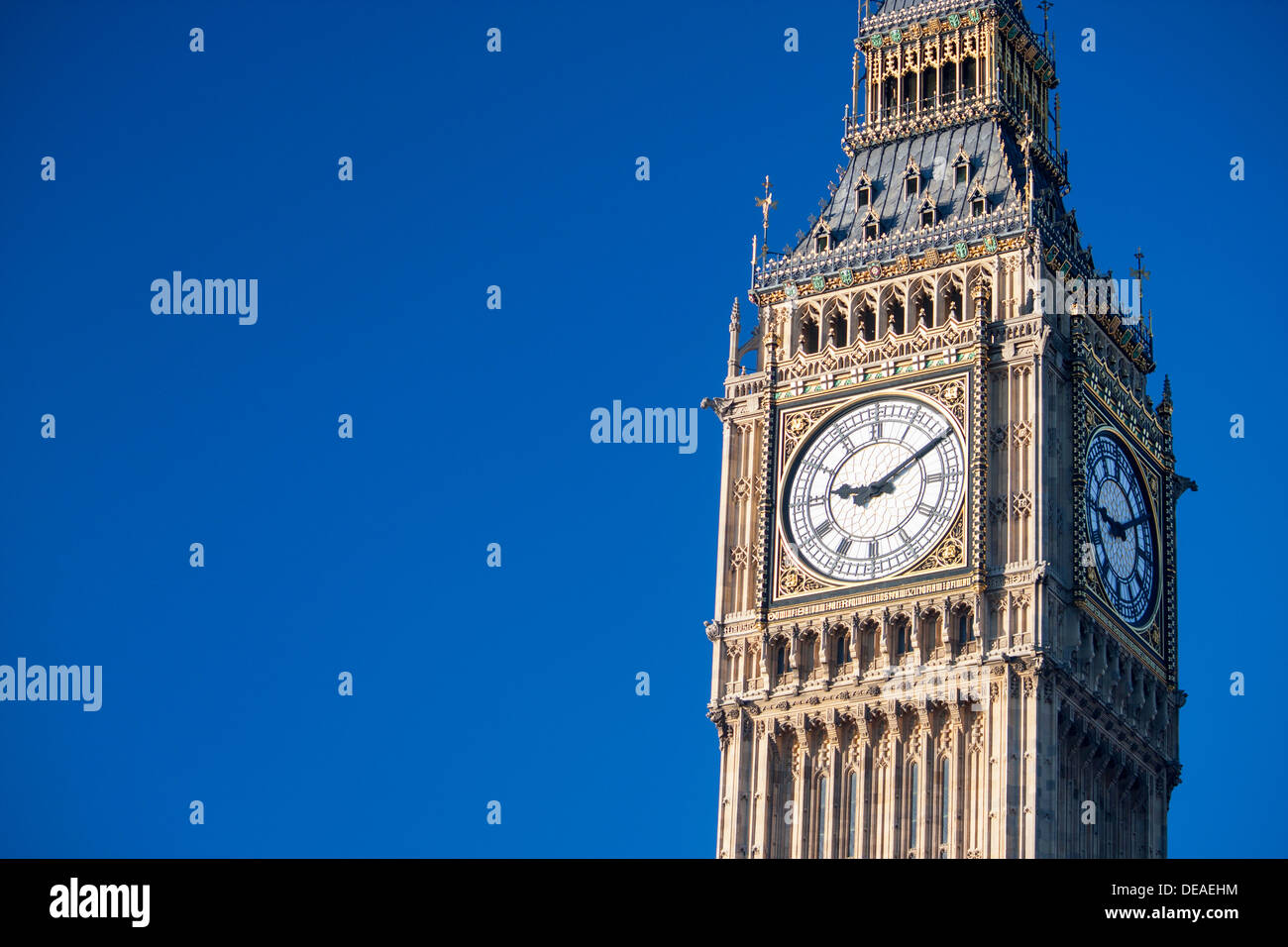 Big Ben Torre del Reloj de Las Casas del Parlamento con la torre a la derecha del bastidor y cielo azul Londres England Reino Unido Foto de stock