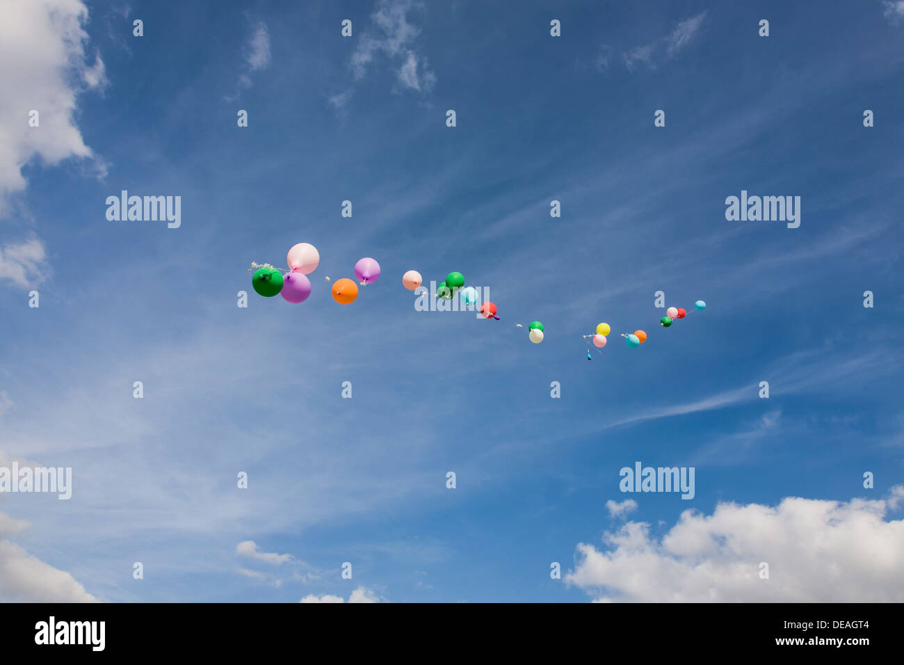 Los globos que flotan en un cielo azul Foto de stock