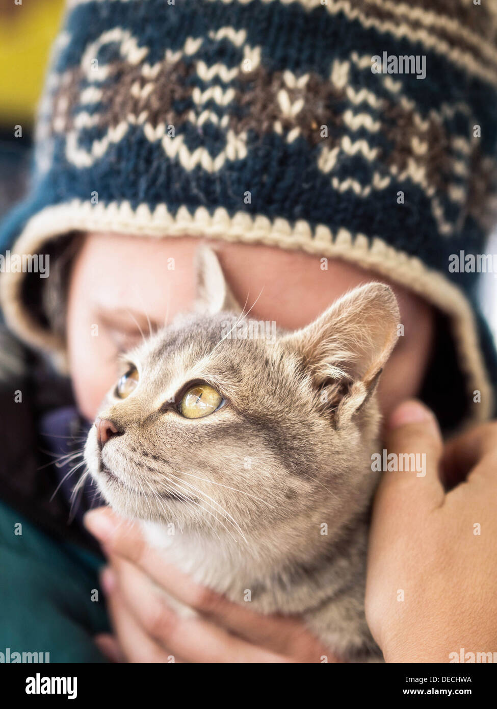 Mujer caucásica cariñosamente sosteniendo su atigrado gatito. Foto de stock