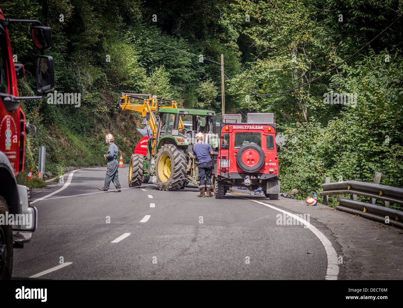 Servicio de Bomberos y el tractor del granjero recuperar el coche que iba más borde del acantilado Foto de stock