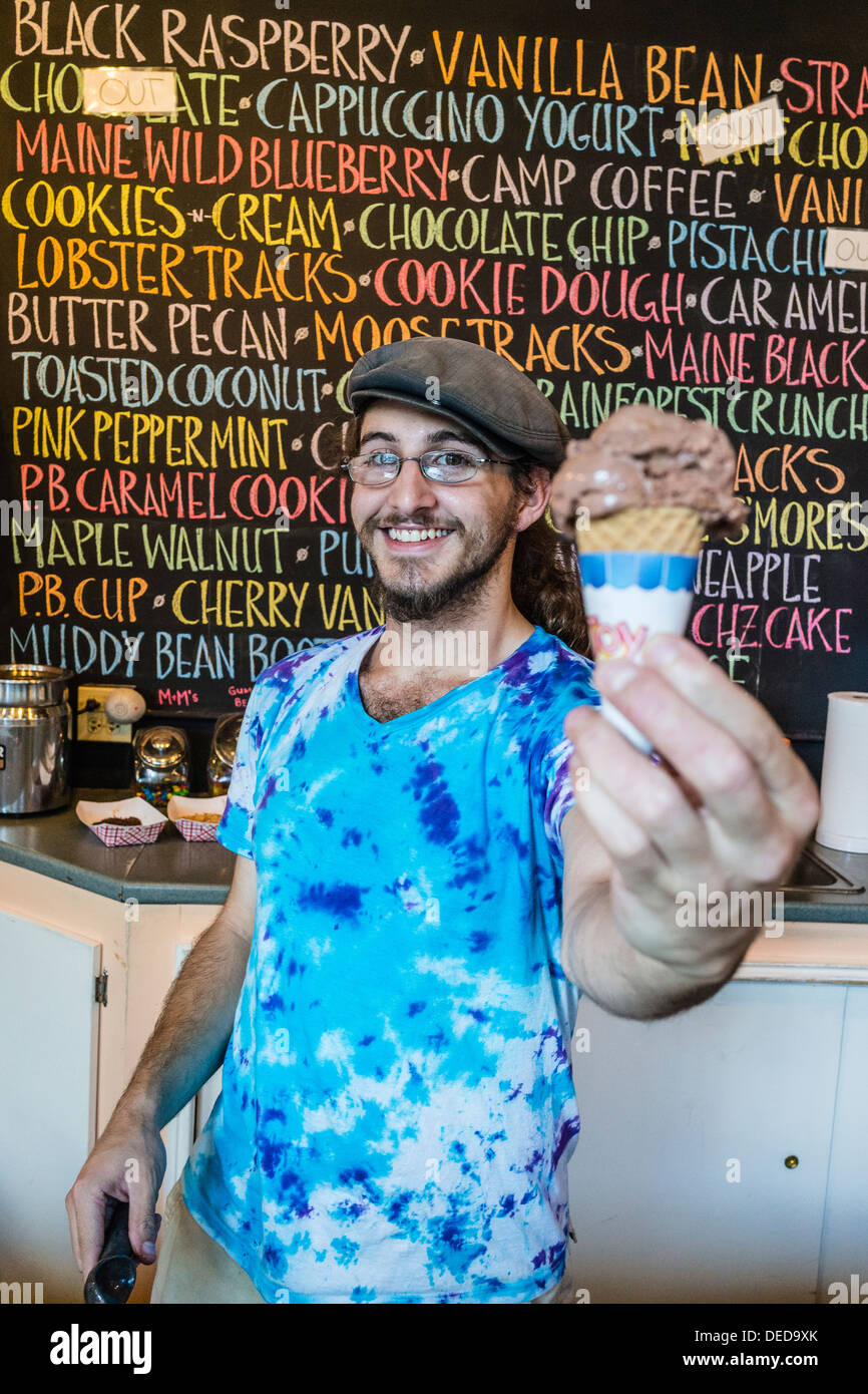 Un cono de helado de chocolate se sirve en la mesa de negociación por un sonriente, jóvenes de sexo masculino de los Thorndike Creamery. Foto de stock