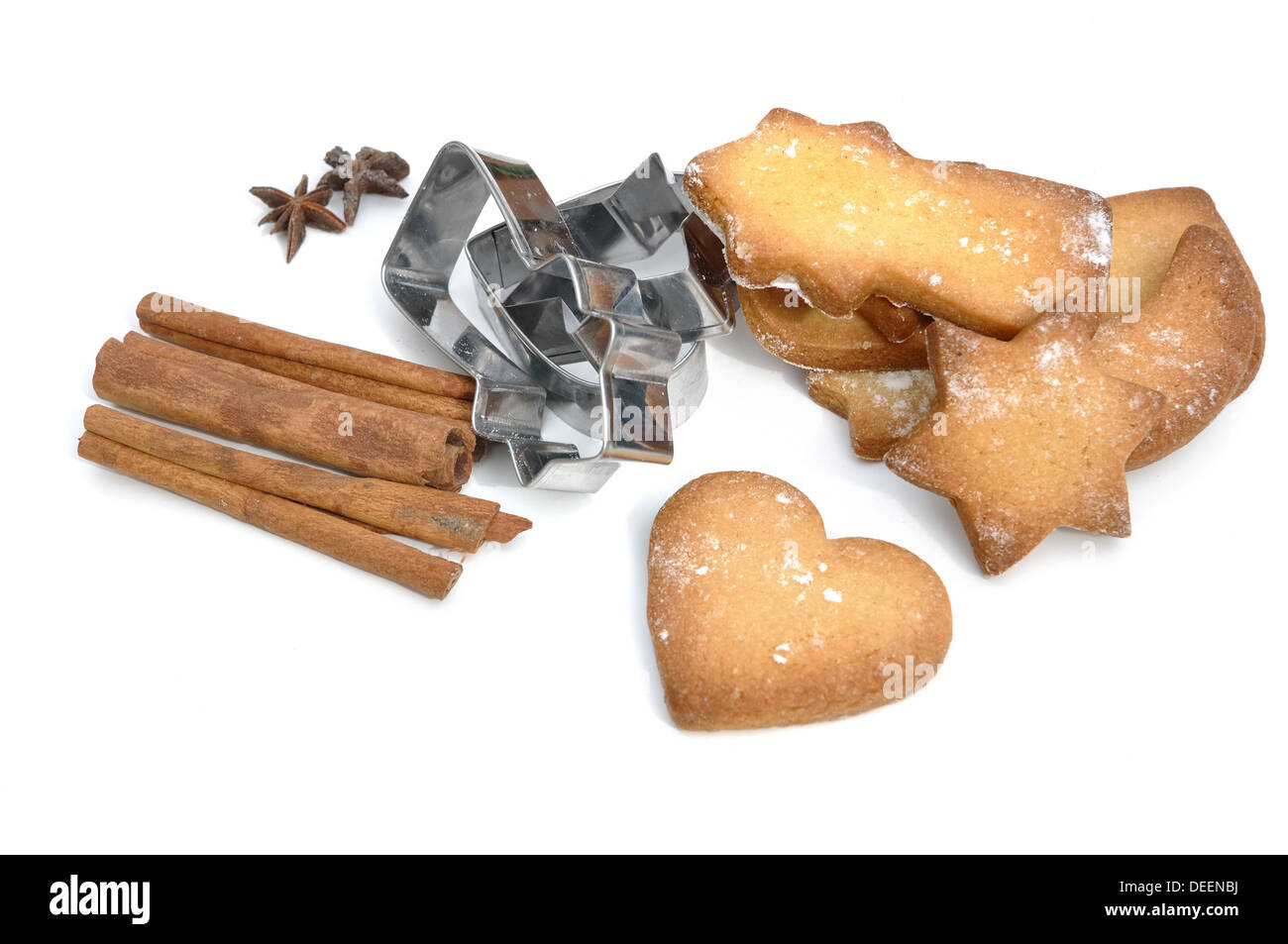 Galletas caseras con especias y cortadores sobre fondo blanco. Foto de stock