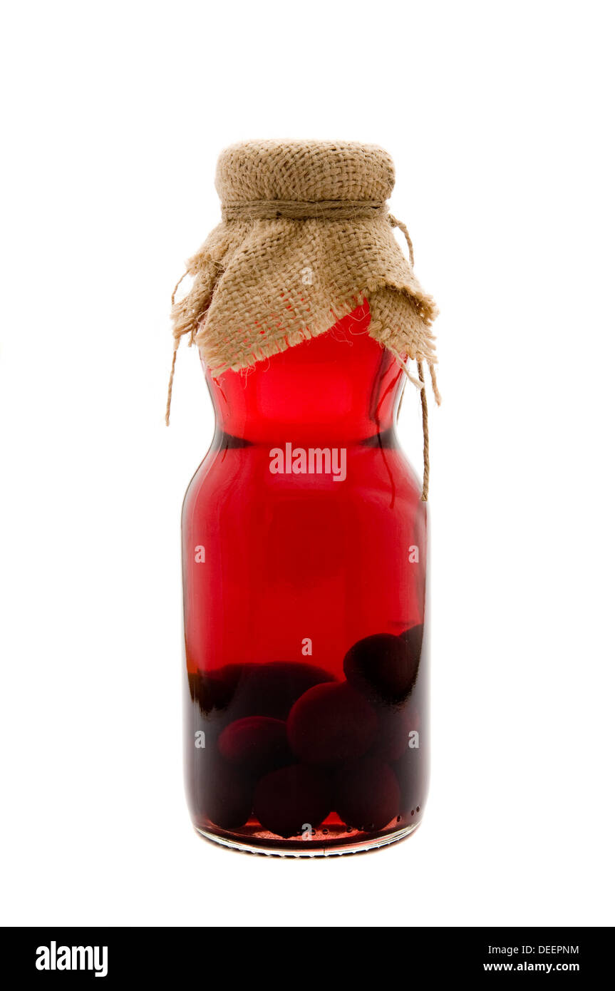 Rustical botella de licor de cereza agria aislado sobre un fondo blanco. Foto de stock