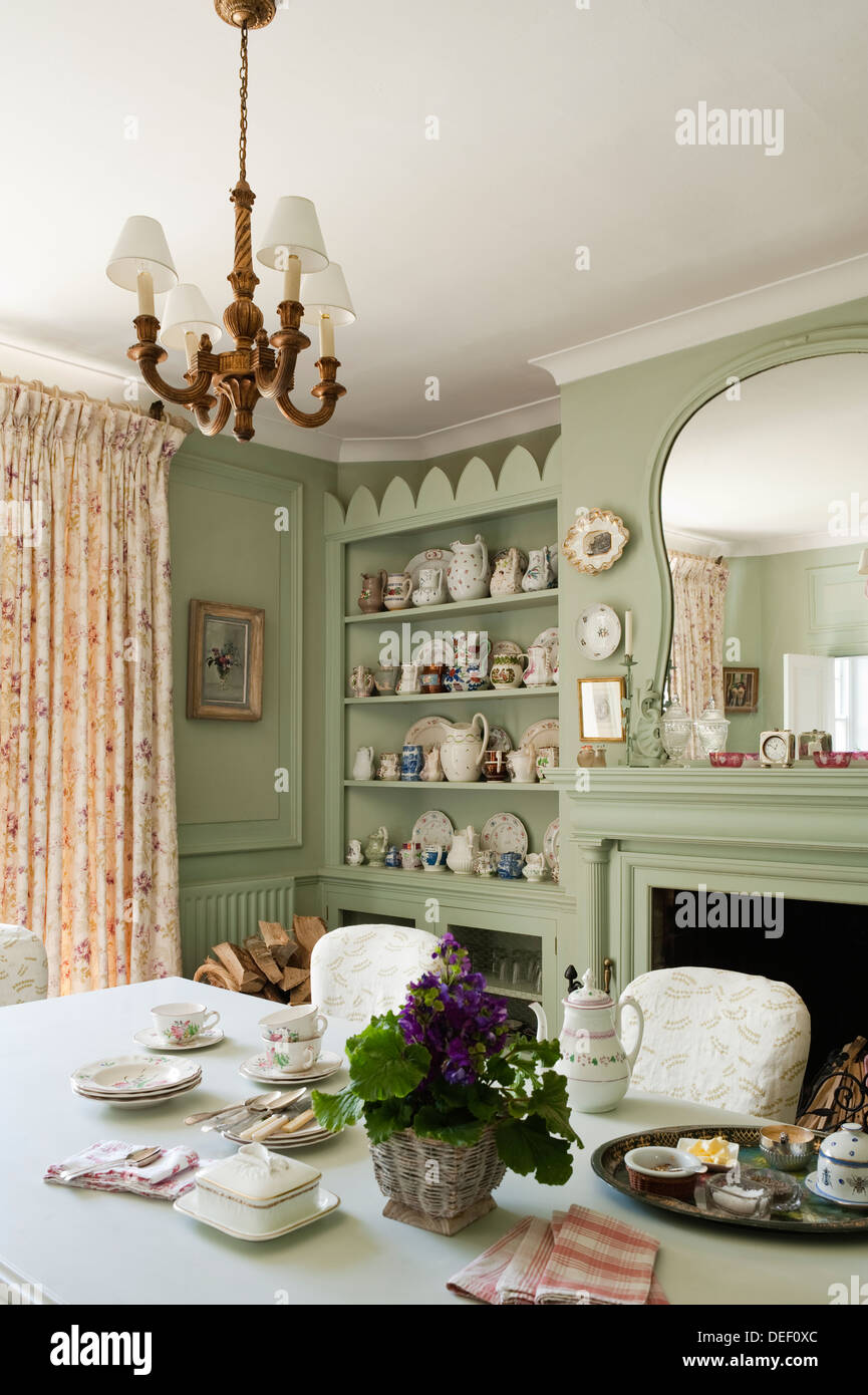 Casa comedor con pottert colección en estantería empotrada pintados en color verde pastel Foto de stock
