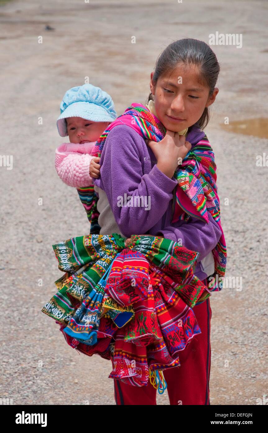 Una joven niña peruana en traje típico que llevaba a un bebé sobre su  espalda en Ollantaytamba, Perú, América del Sur Fotografía de stock - Alamy