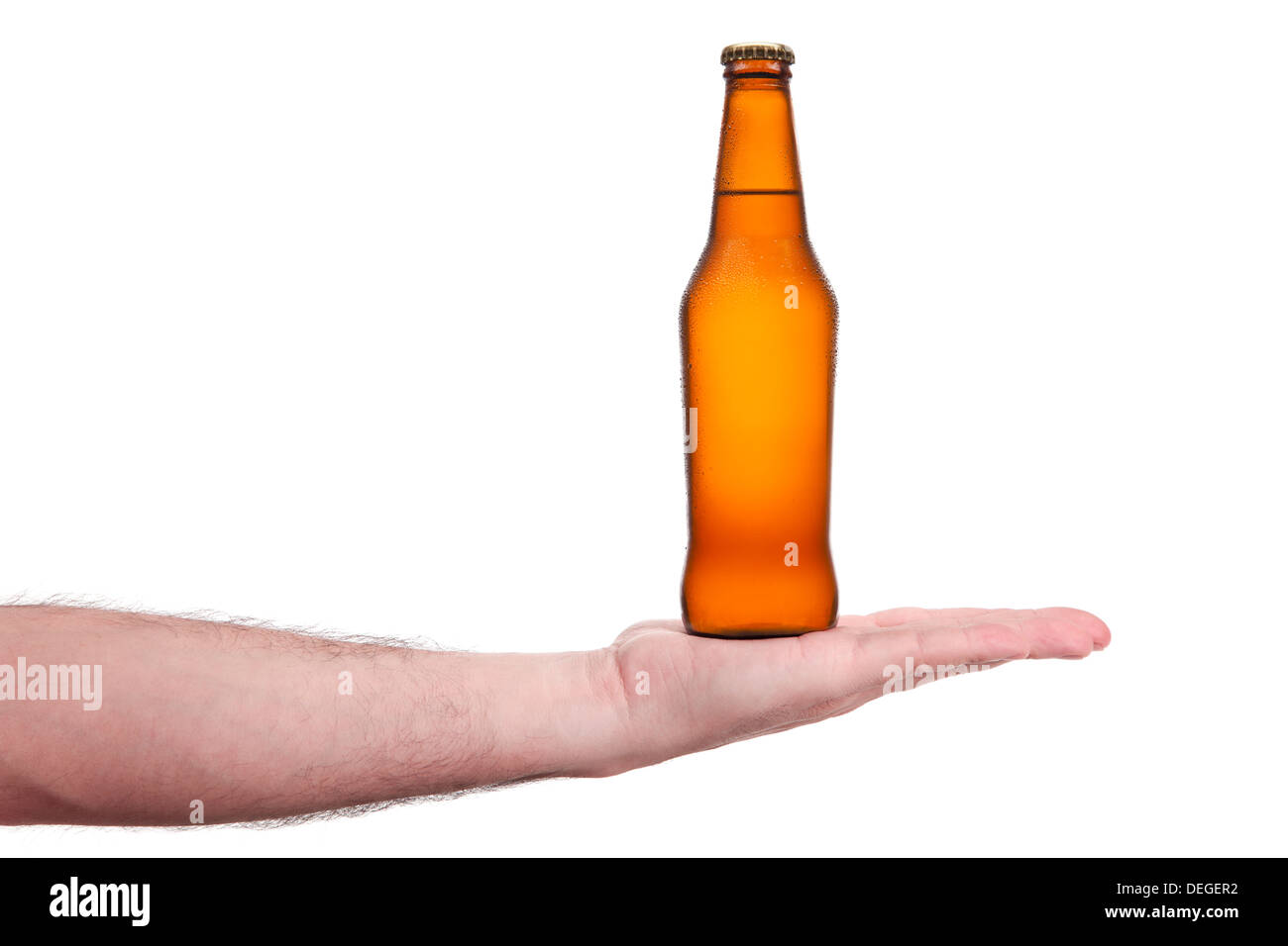 Una botella de cerveza en la palma de una mano. Foto de stock