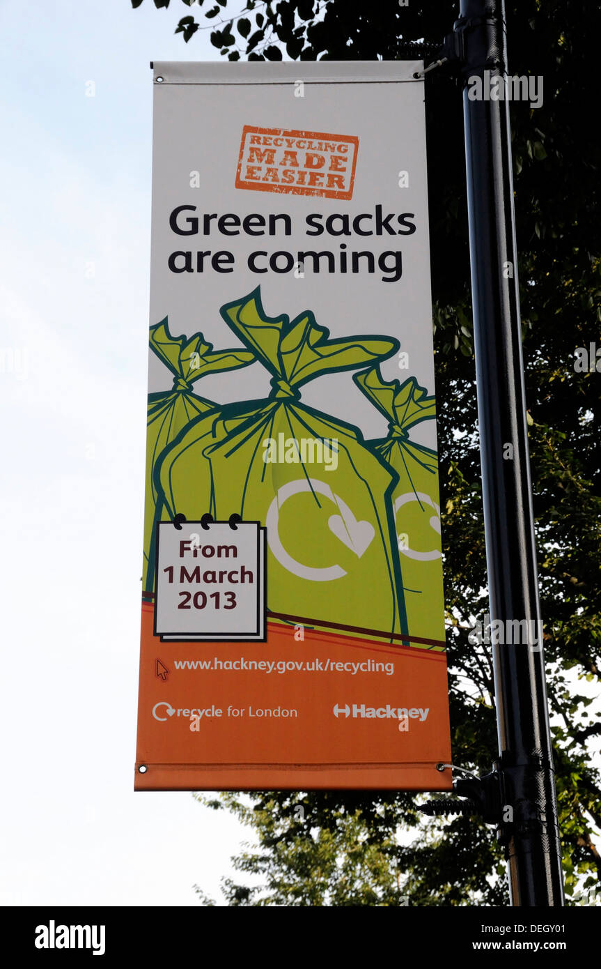 Pancarta diciendo sacos verdes vienen colgando de farola para alentar a los residentes locales a reciclar sus desechos de Hackney, Londres, Gran Bretaña. Foto de stock