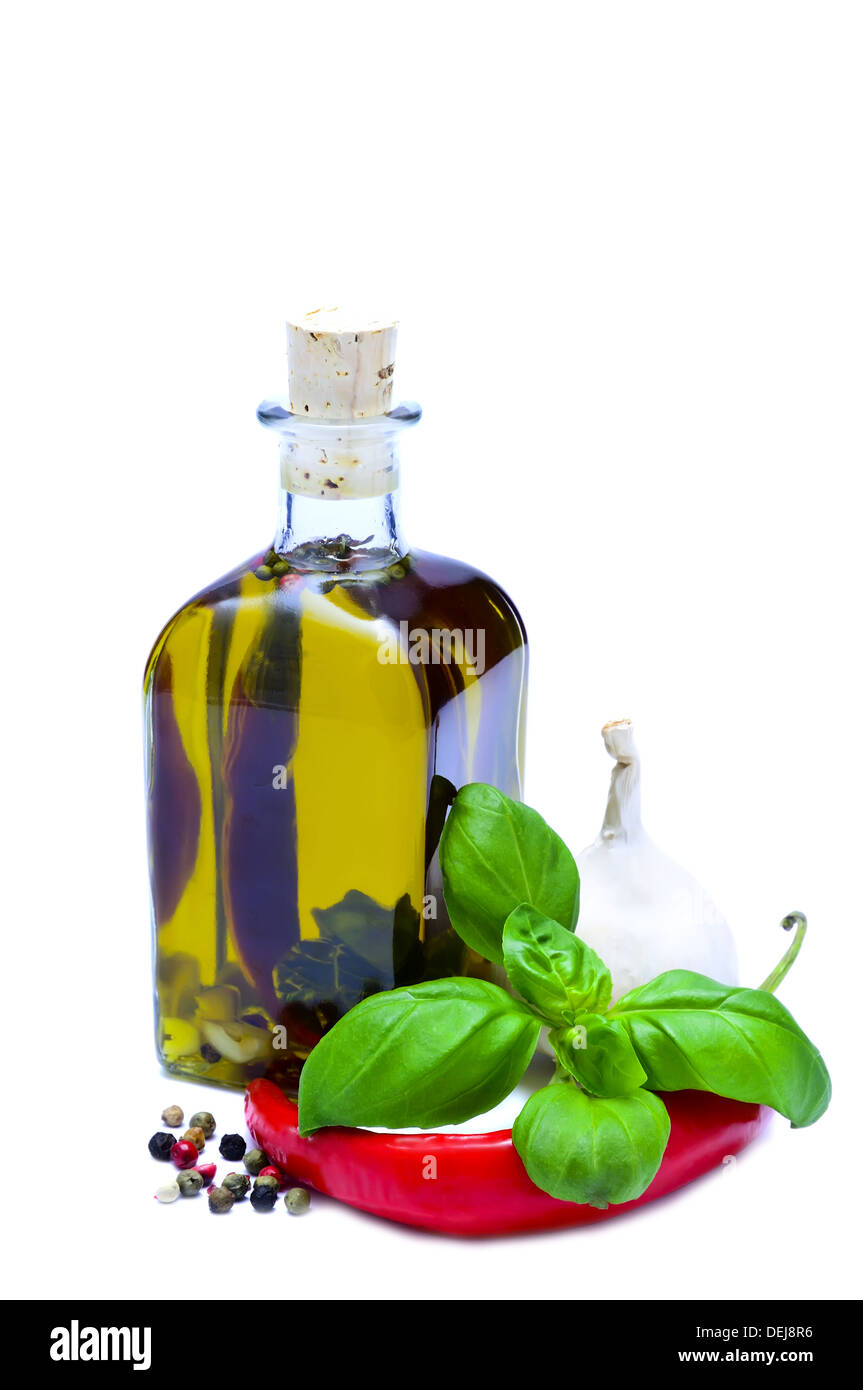 Botella de aceite de oliva infundido con pimienta, pimentón, ajo y albahaca aislado sobre un fondo blanco. Foto de stock