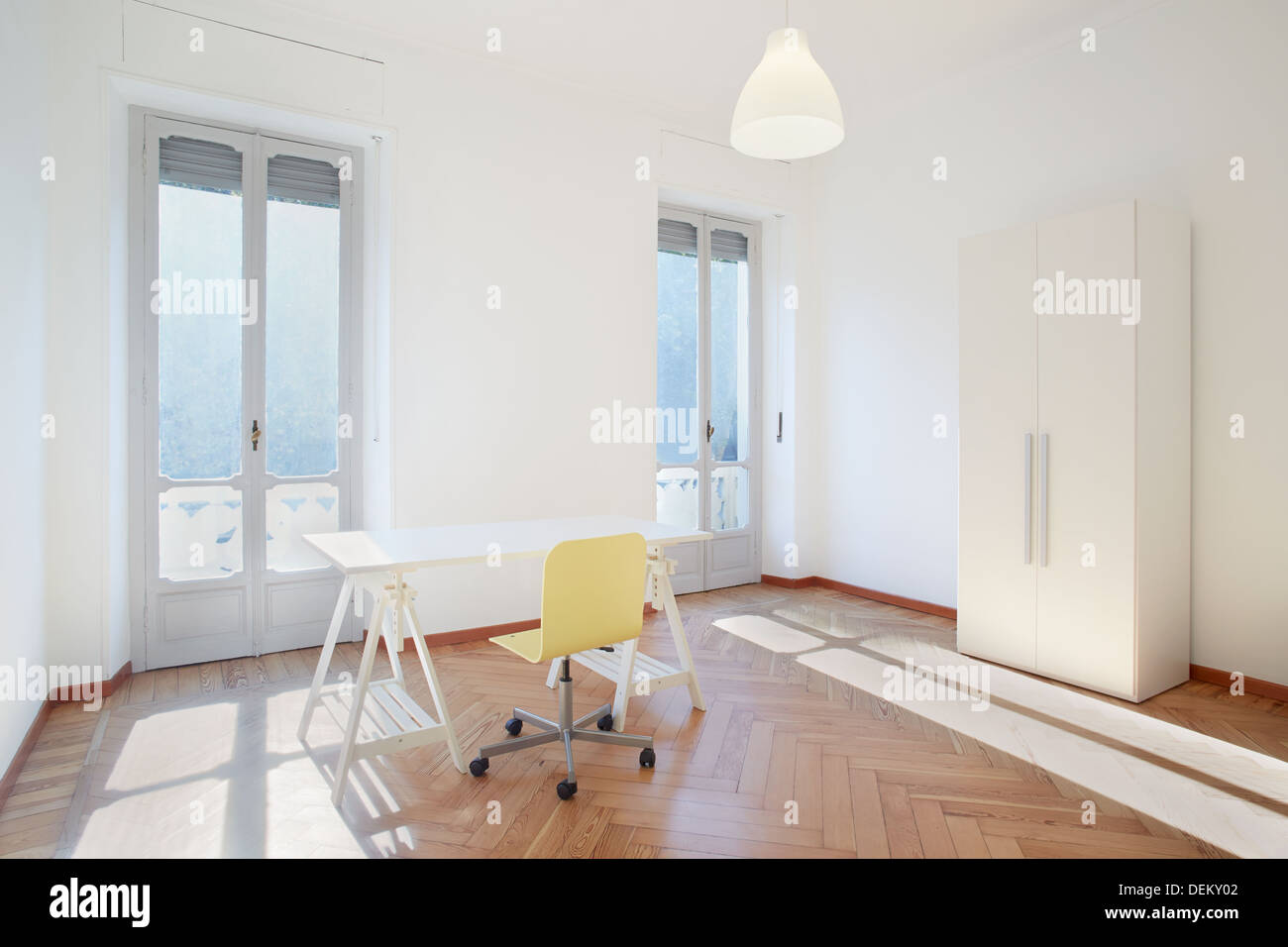 Luminosa habitación estudio con escritorio y silla en el nuevo apartamento Foto de stock