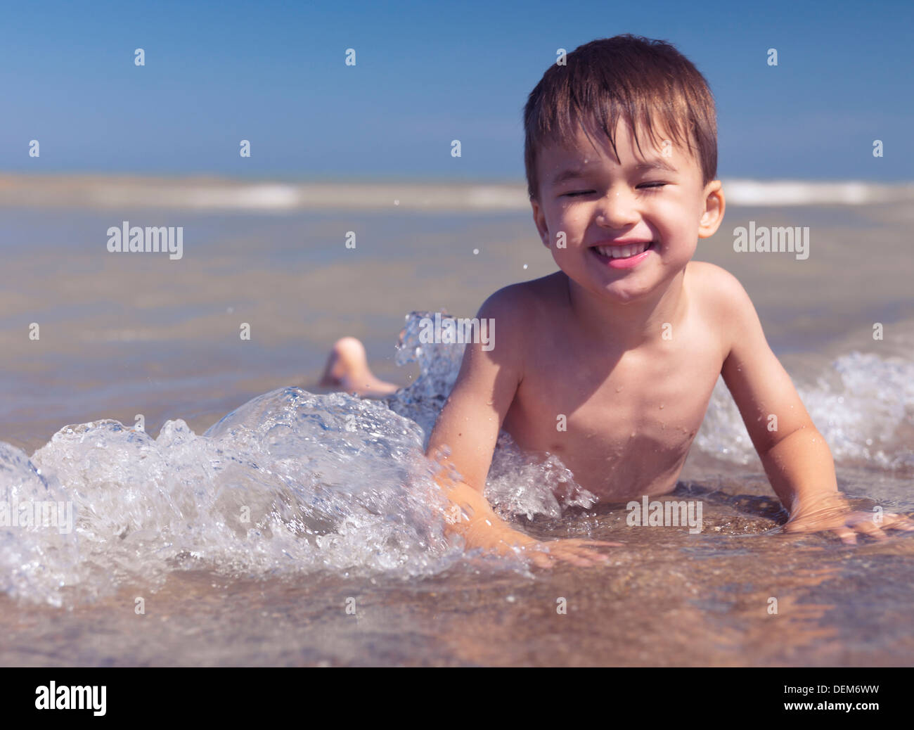 Lindo muchacho de tres años felices chapoteando en el agua poco profunda en una orilla del lago Huron. En Ontario, Canadá. Foto de stock