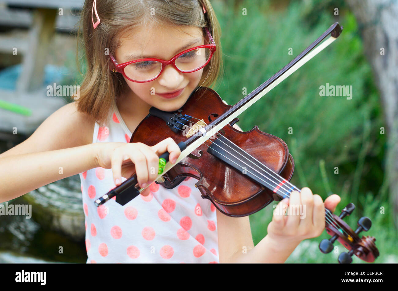 Chica hispana a tocar el violín en el exterior Foto de stock