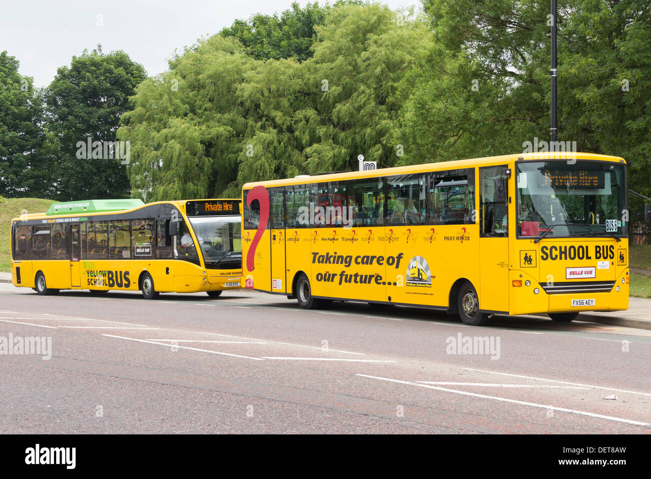 Dos autobuses amarillos escolares (UK variedad) de Manchester. La parte trasera es un autobús híbrido Versa Optare eléctrico/diesel de baja emisión de vehículos. Foto de stock