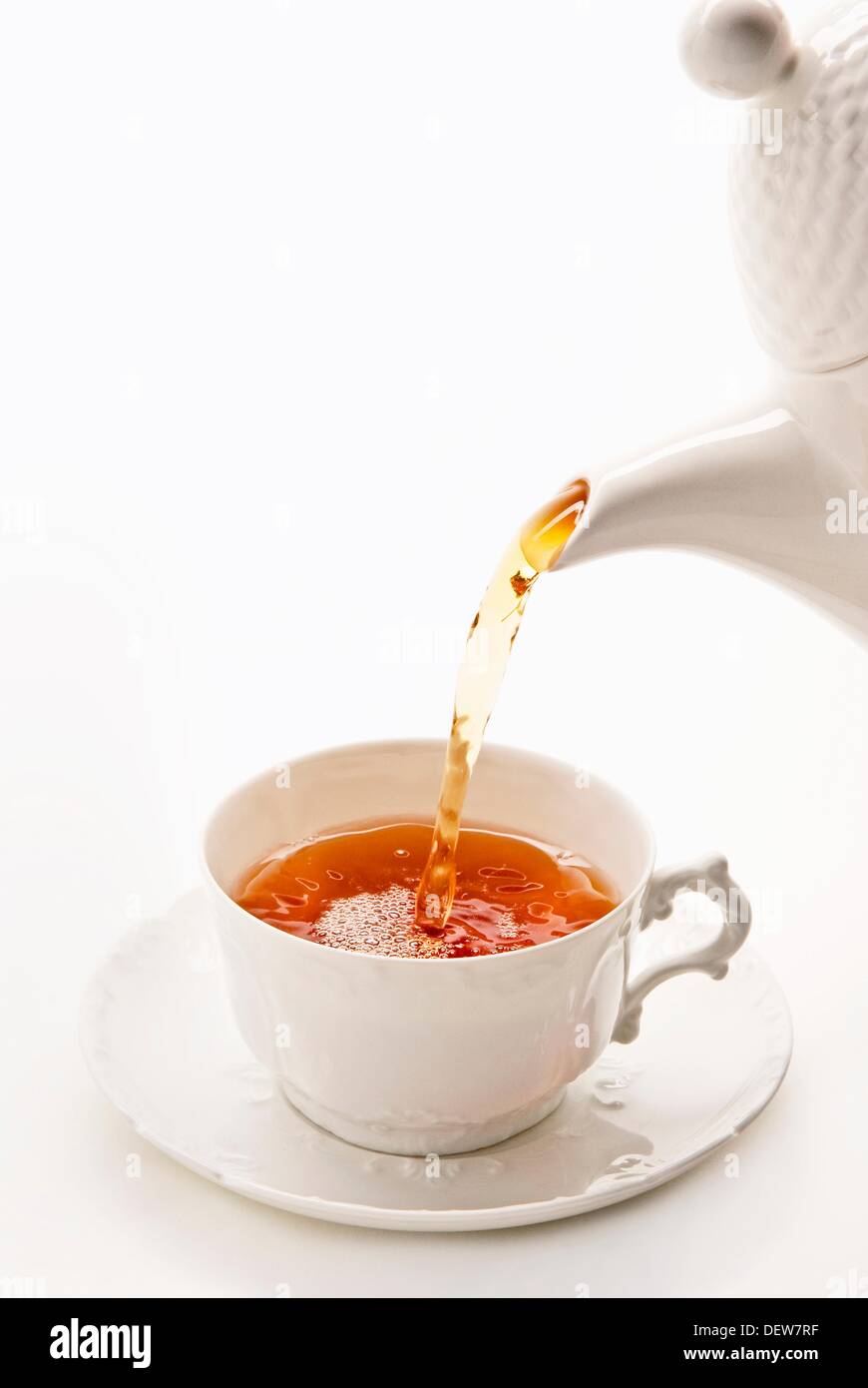 Verter el té en taza de porcelana china blanca Foto de stock