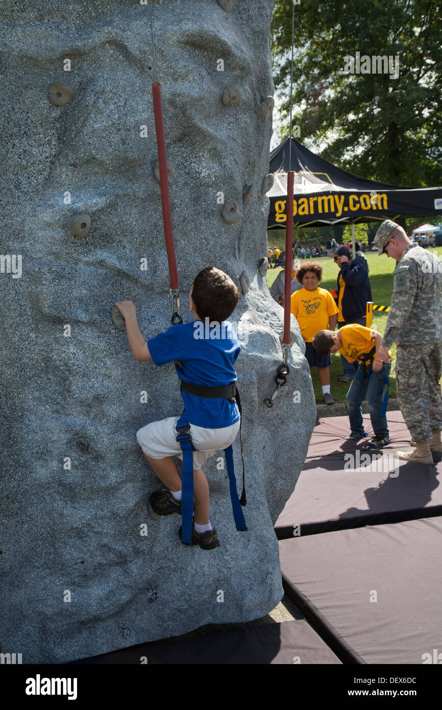 New Boston, Michigan - una tropa de Boy Scouts en una pared de escalada en un stand del ejército durante un encuentro Scout en un parque de Detroit suburbano. Foto de stock
