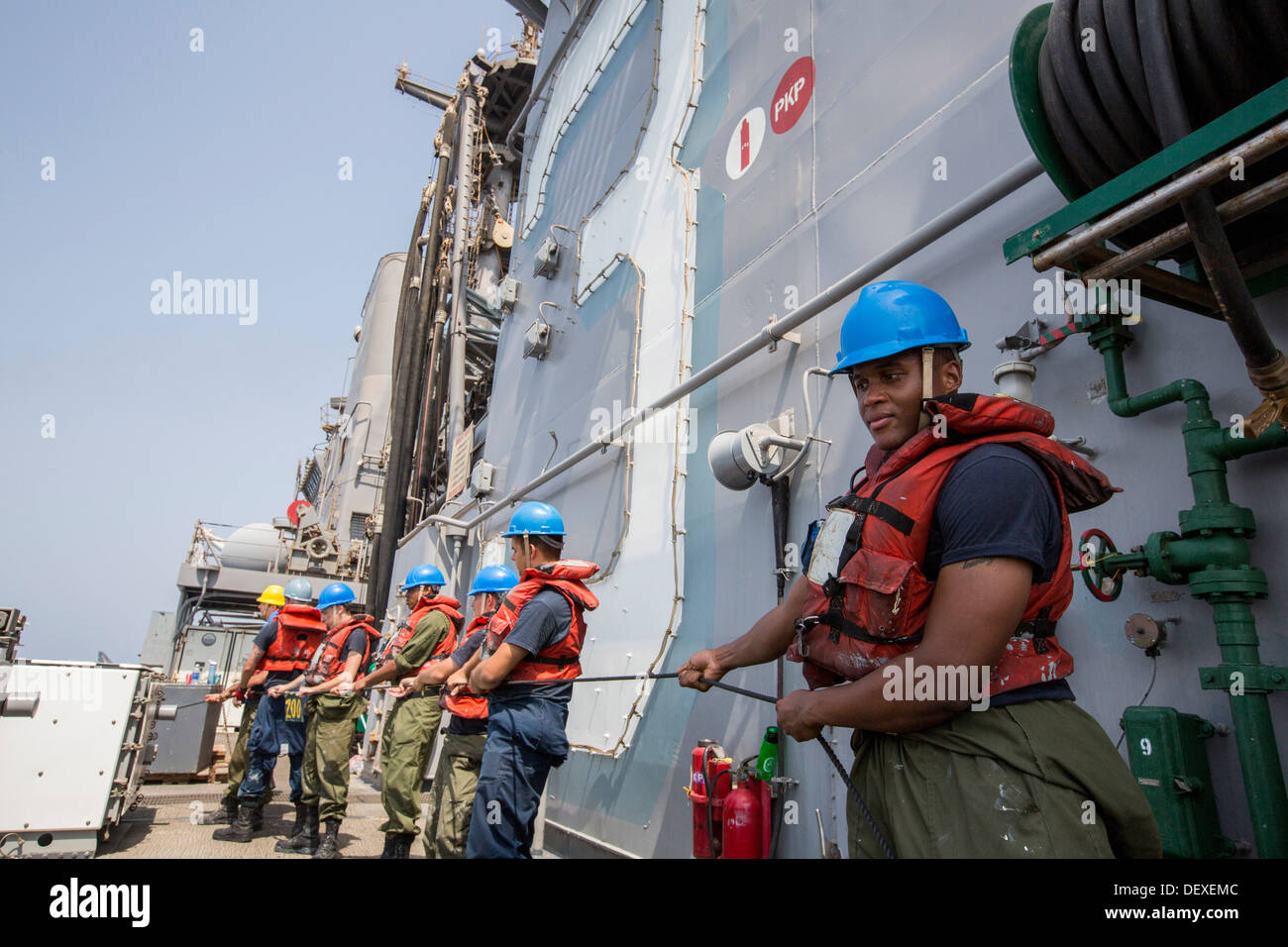 Los marineros del hombre una línea de teléfono y distancia durante una reposición en alta mar a bordo del buque de asalto anfibio USS Kearsarge (LHD 3). K Foto de stock
