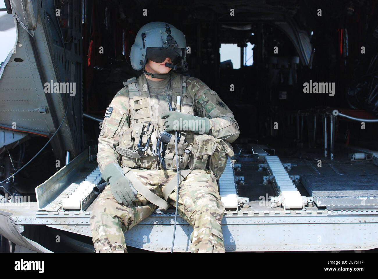El Sgt. Dan Glenn, un helicóptero Chinook CH-47 ingeniero de vuelo asignado a la compañía B, 2º Batallón (apoyo general), 149º Regimiento de Aviación (Texas/Guardia Nacional de Oklahoma), sirviendo bajo la 10ª Brigada de Aviación de Combate, se comunica con la tripulación de la aeronave Foto de stock