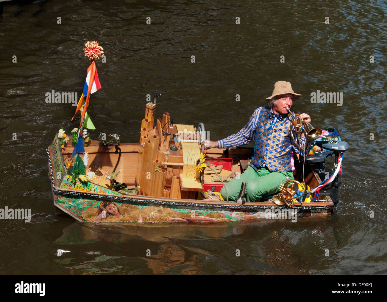 Un músico callejero ( Reinier Sijpkens ) tocando la trompeta en un órgano barco sobre un canal en Amsterdam, Países Bajos Foto de stock