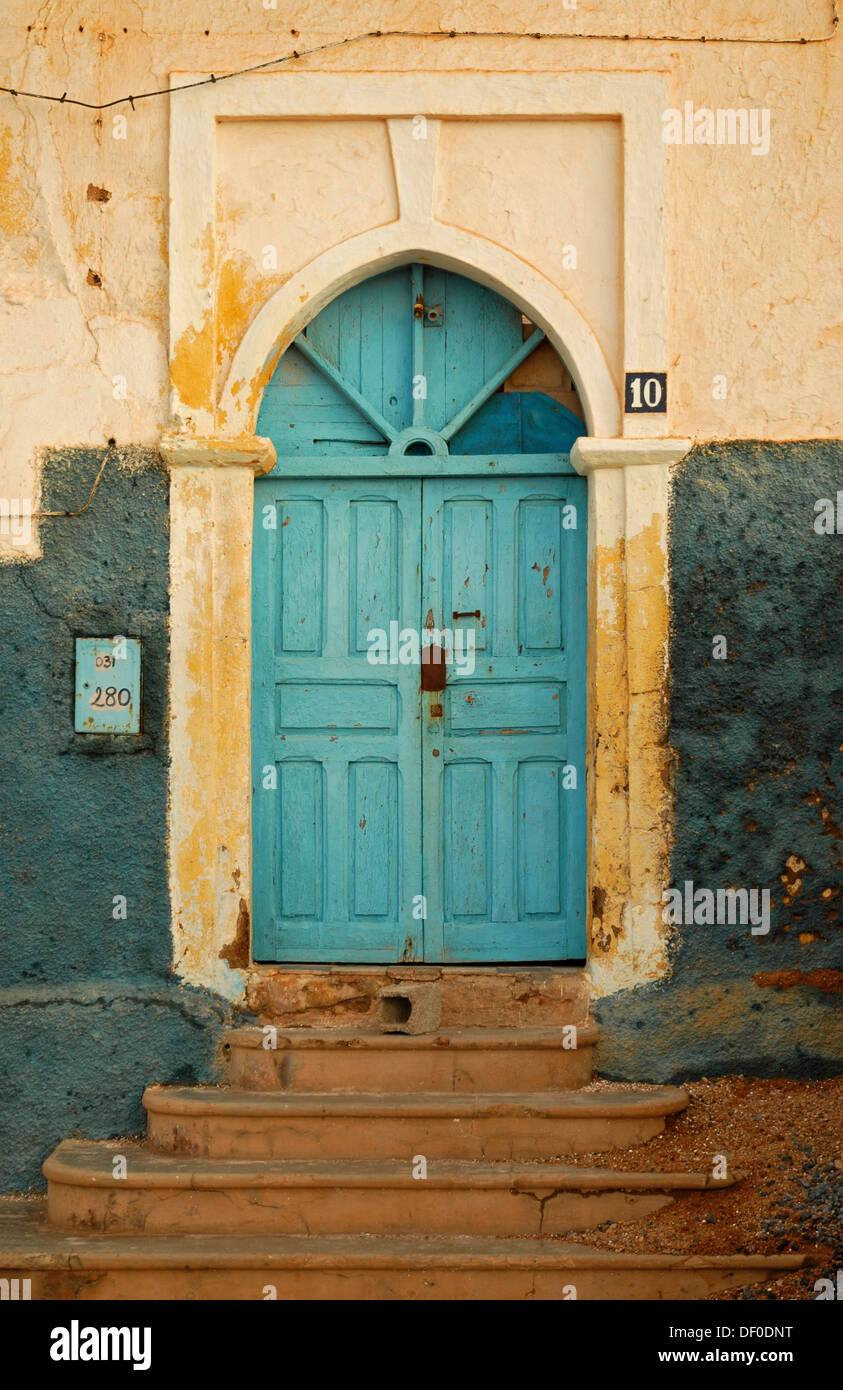 En forma típicamente puerta azul sobre una fachada blanca de Sidi Ifni, Marruecos, África Foto de stock