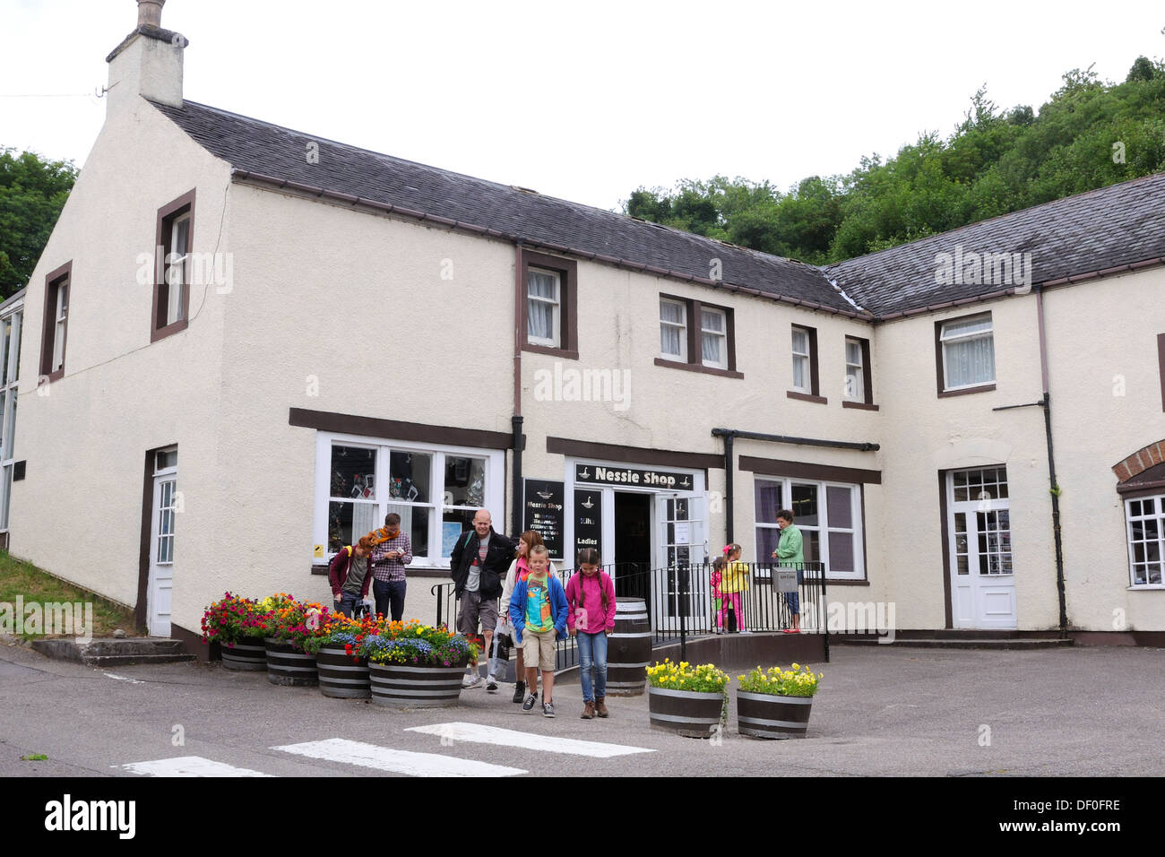 Una familia que deja la tienda Nessie en Drumnadrochit Foto de stock