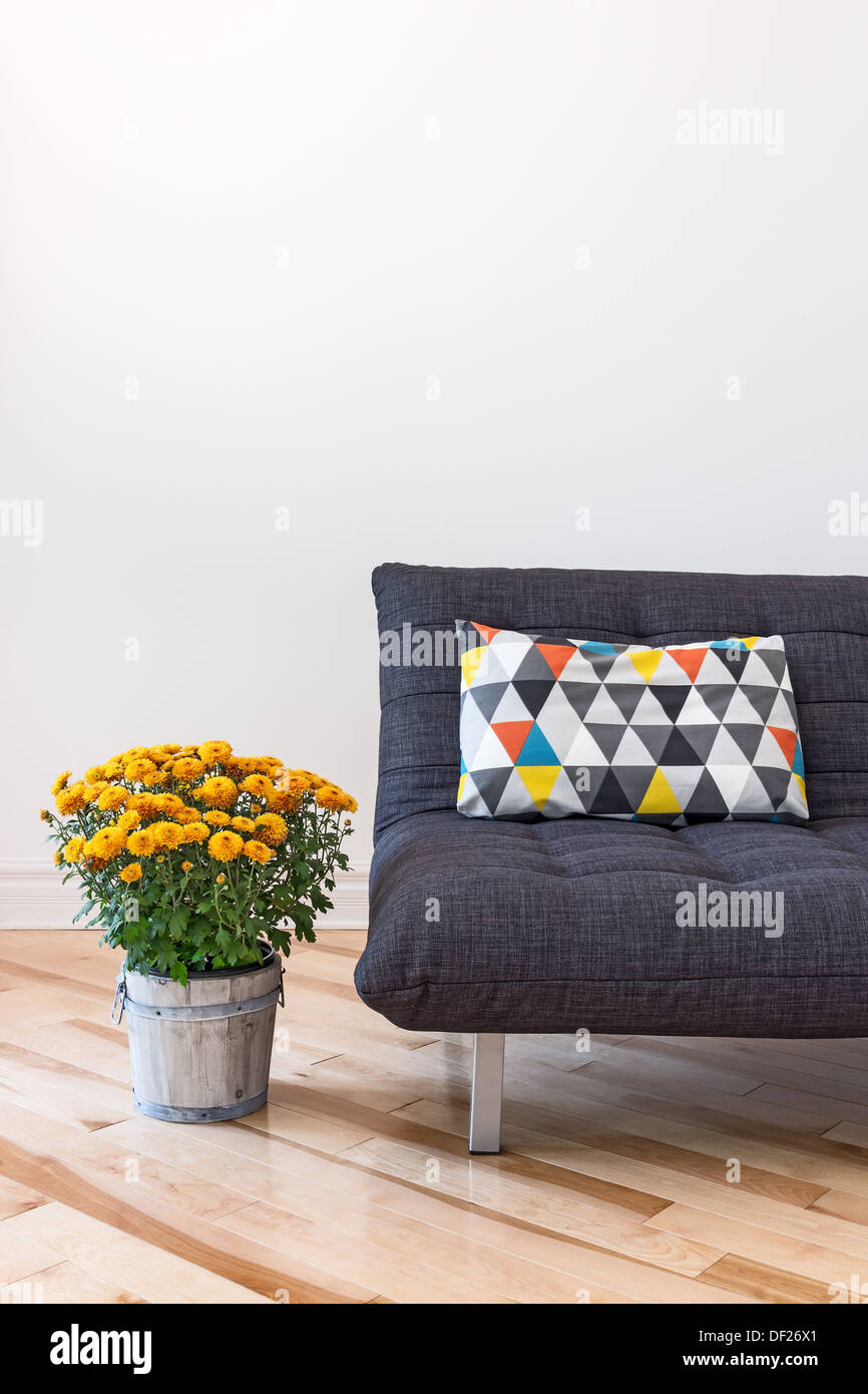 Gris, sillón cómodo, flor sobre una mesa y la pintura sobre la pared azul  en el salón interior Fotografía de stock - Alamy