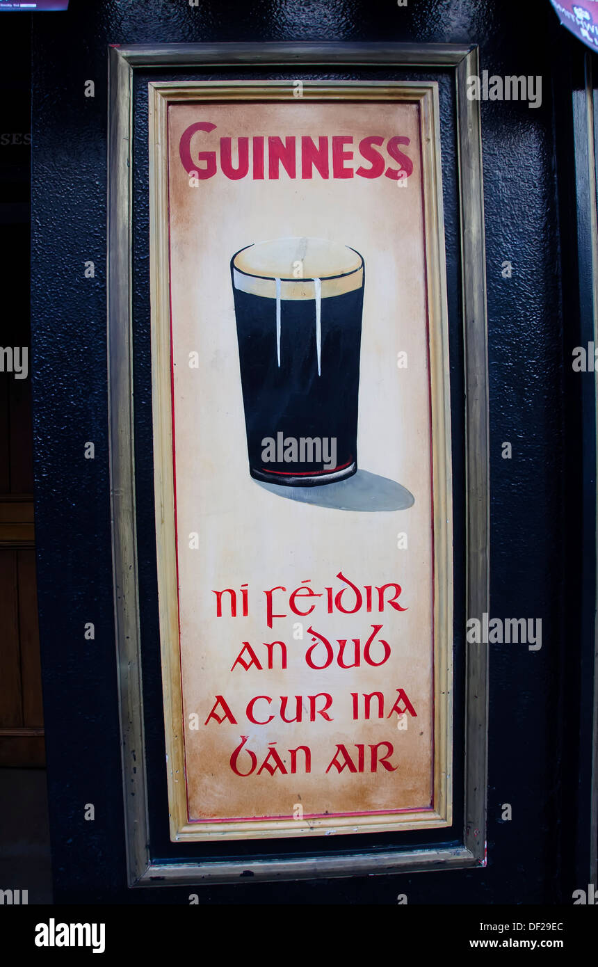 Pub irlandés con Guinness ad cartel tanto en inglés y en gaélico, Kilkenny, Irlanda Foto de stock