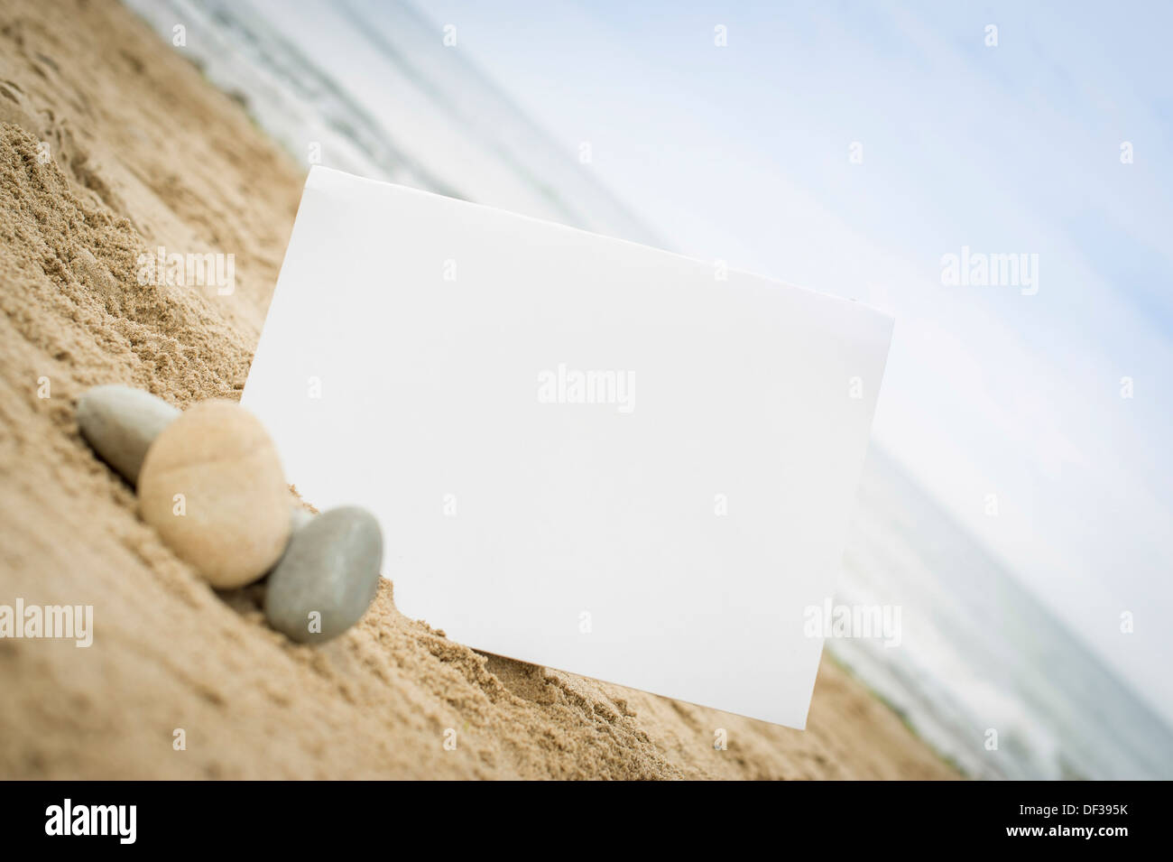 Firmar en blanco en una playa de arena con piedras y guijarros Foto de stock