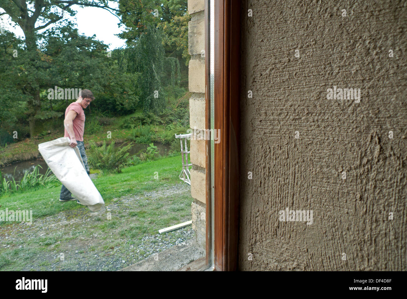 Llanwrda, Gales, Reino Unido Viernes 27 de septiembre de 2013. Los detalles en primer plano de la primera capa gruesa de cáñamo, cal yeso en una pared interior de un granero de piedra galés en obras de renovación. Este especialista enyesado técnica es utilizada por eco-constructor Neil penacho de 'Grand(ish) Diseños' que ofrece servicios de construcción sostenible verde en Carmarthenshire, Sur, Oeste y Centro de Gales UK en ambos edificios nuevos y tradicionales. Kathy deWitt/Alamy Live News Foto de stock