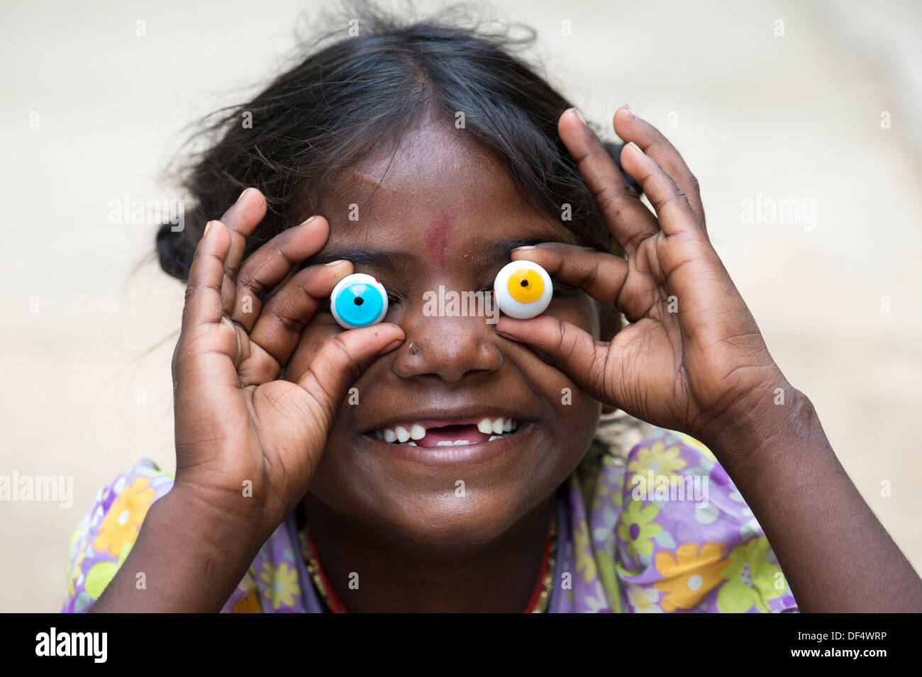 Pobre niña india gracioso feliz celebración ojos de mármol con una sonrisa desdentada. La India Foto de stock
