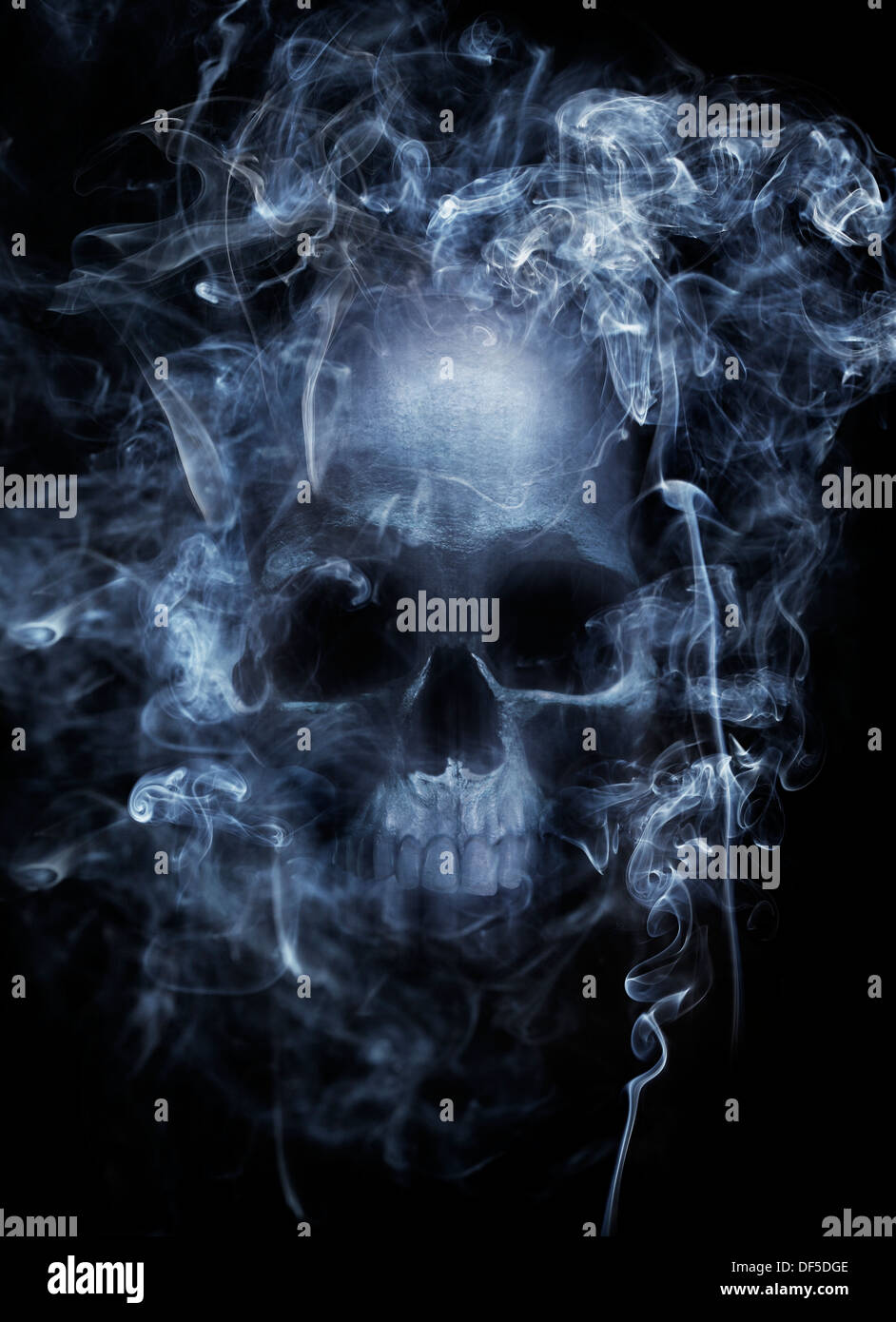 Foto montaje de un cráneo humano rodeado de humo de cigarrillo. Foto de stock