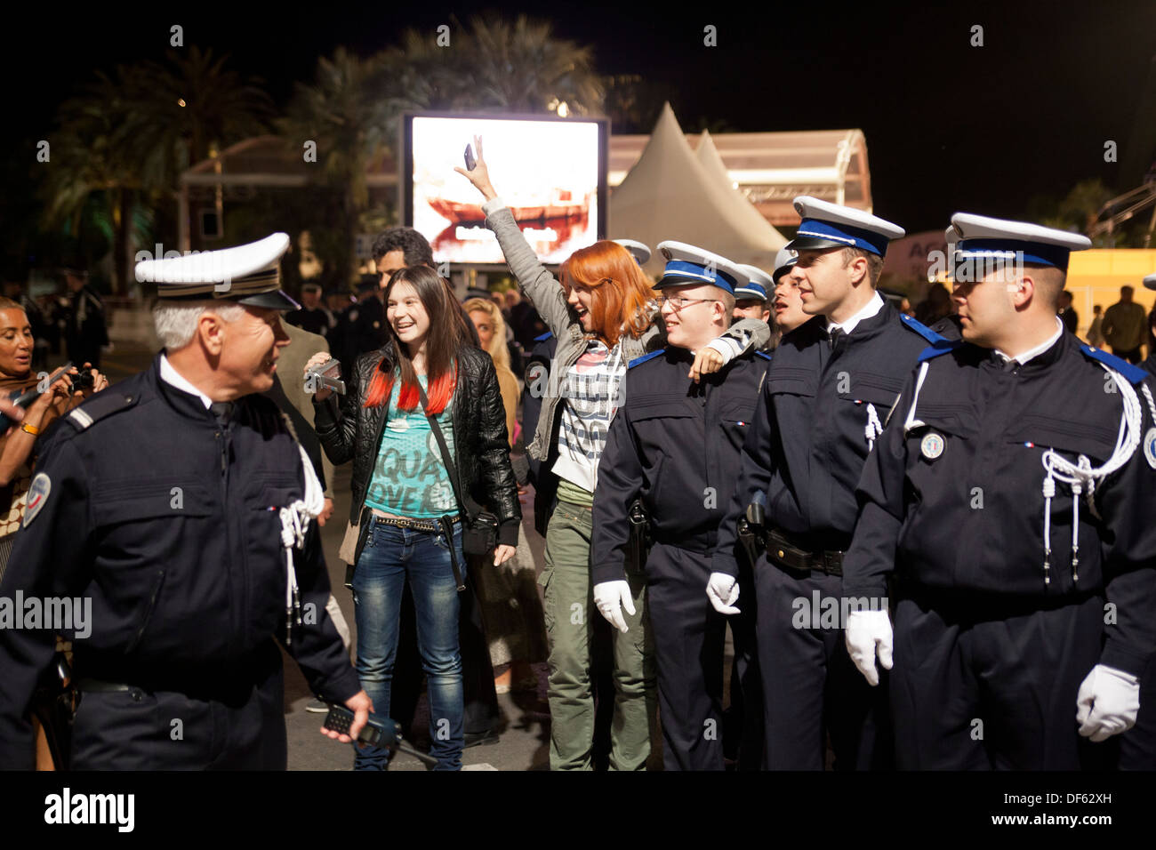 Las personas plantean con los gendarmes (policías franceses) fuera del "Palais des Festivals" en el Festival de Cine de Cannes Foto de stock