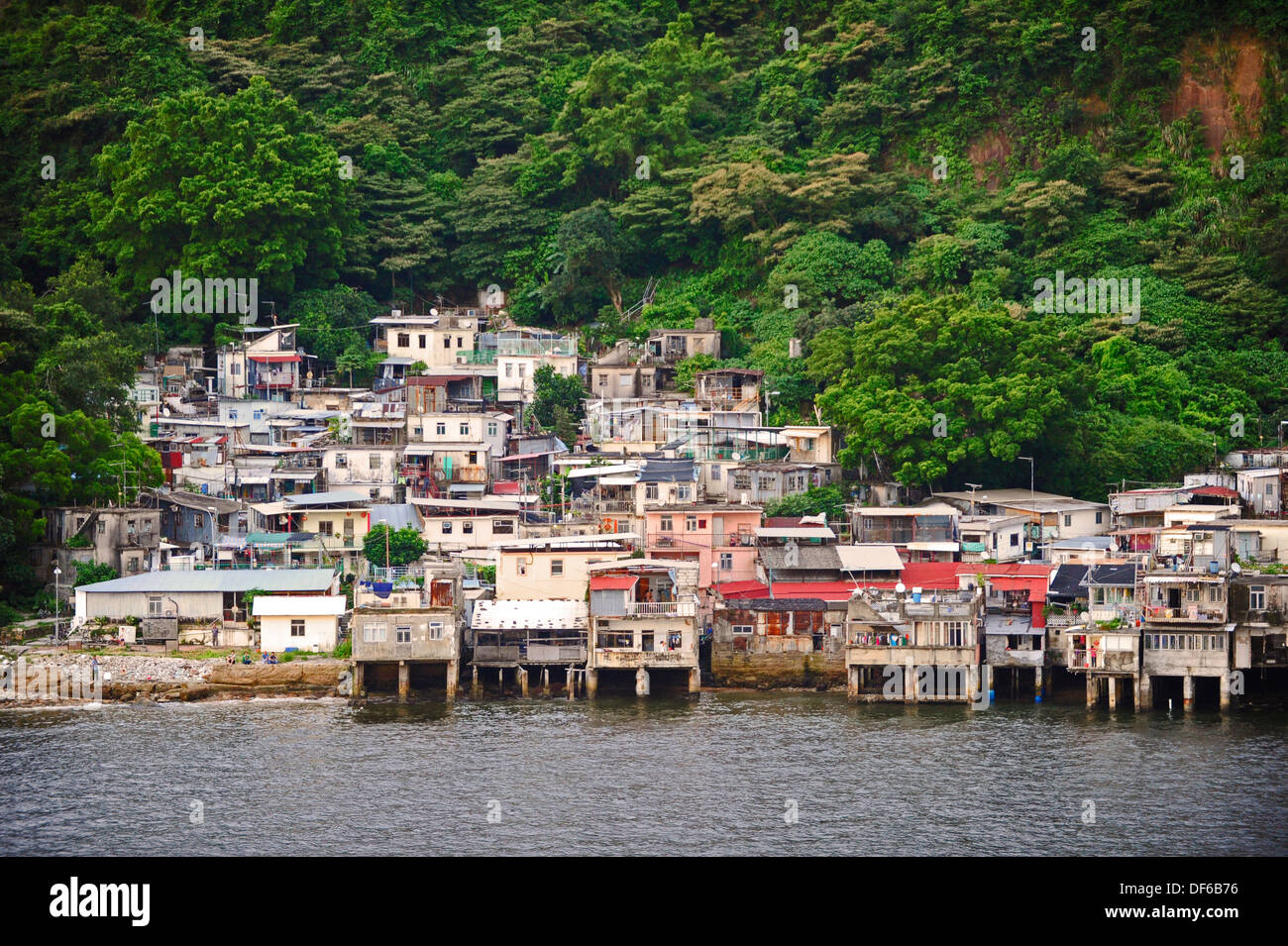 Pequeño poblado de chabolas con casas improvisadas y viviendas en la costa fuera de Hong Kong. Foto de stock