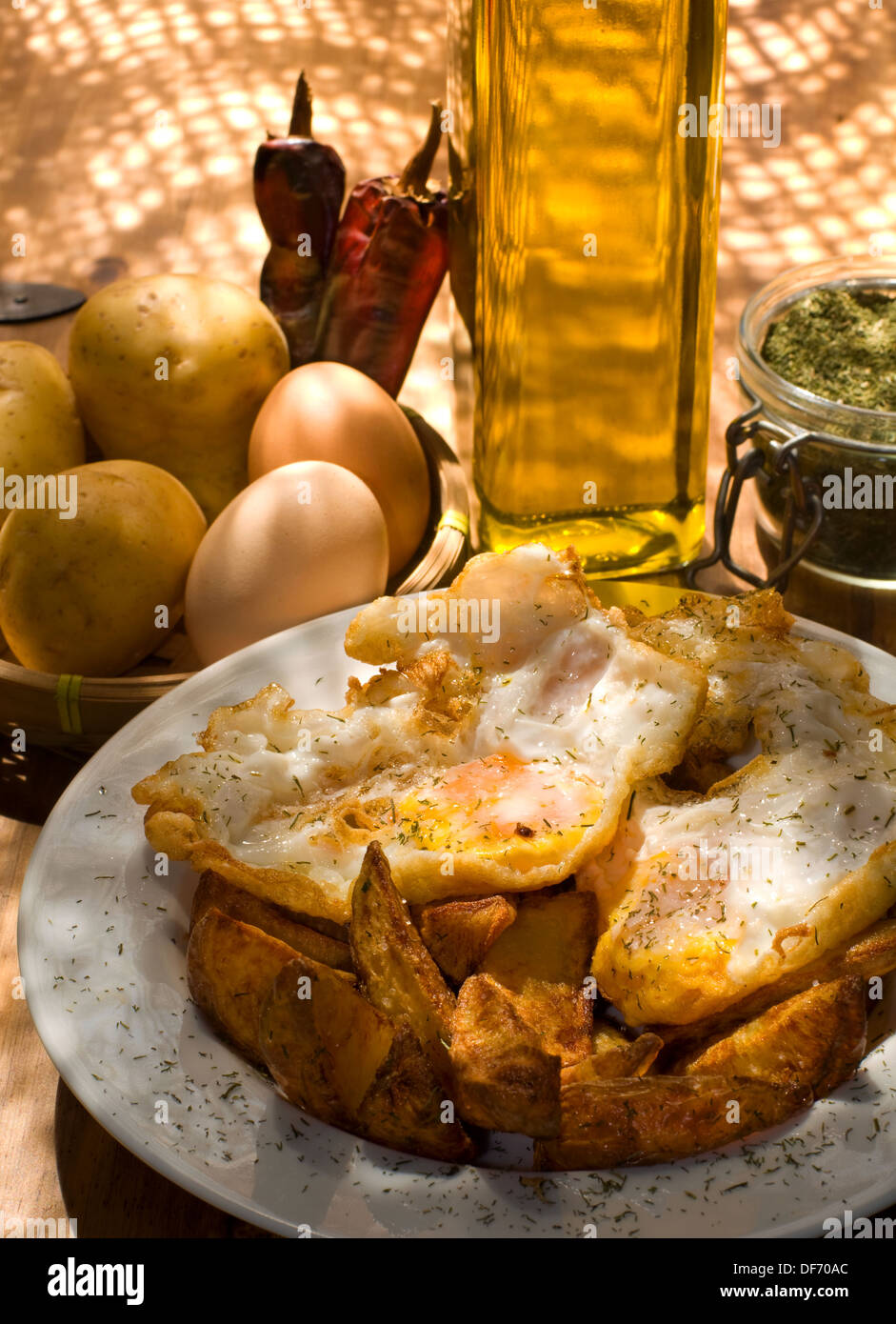La cocina española. Huevos fritos con patatas servido en una placa blanca. Foto de stock