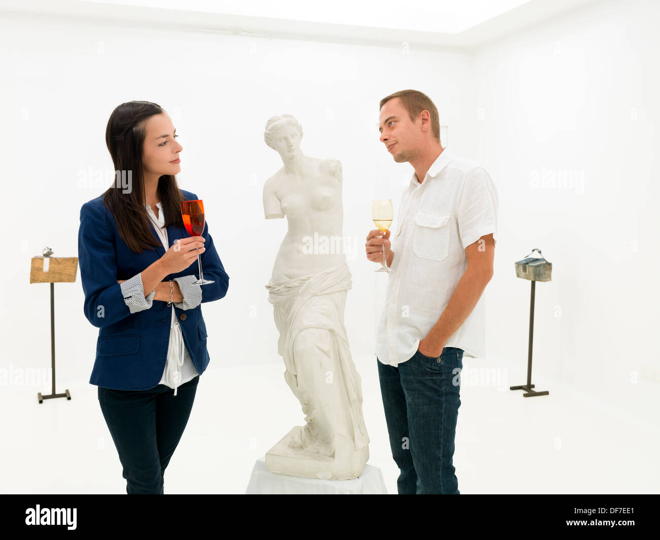 Joven Pueblo Caucasiano sonrisa mutuamente de pie junto a una estatua de arte en un museo de arte Foto de stock