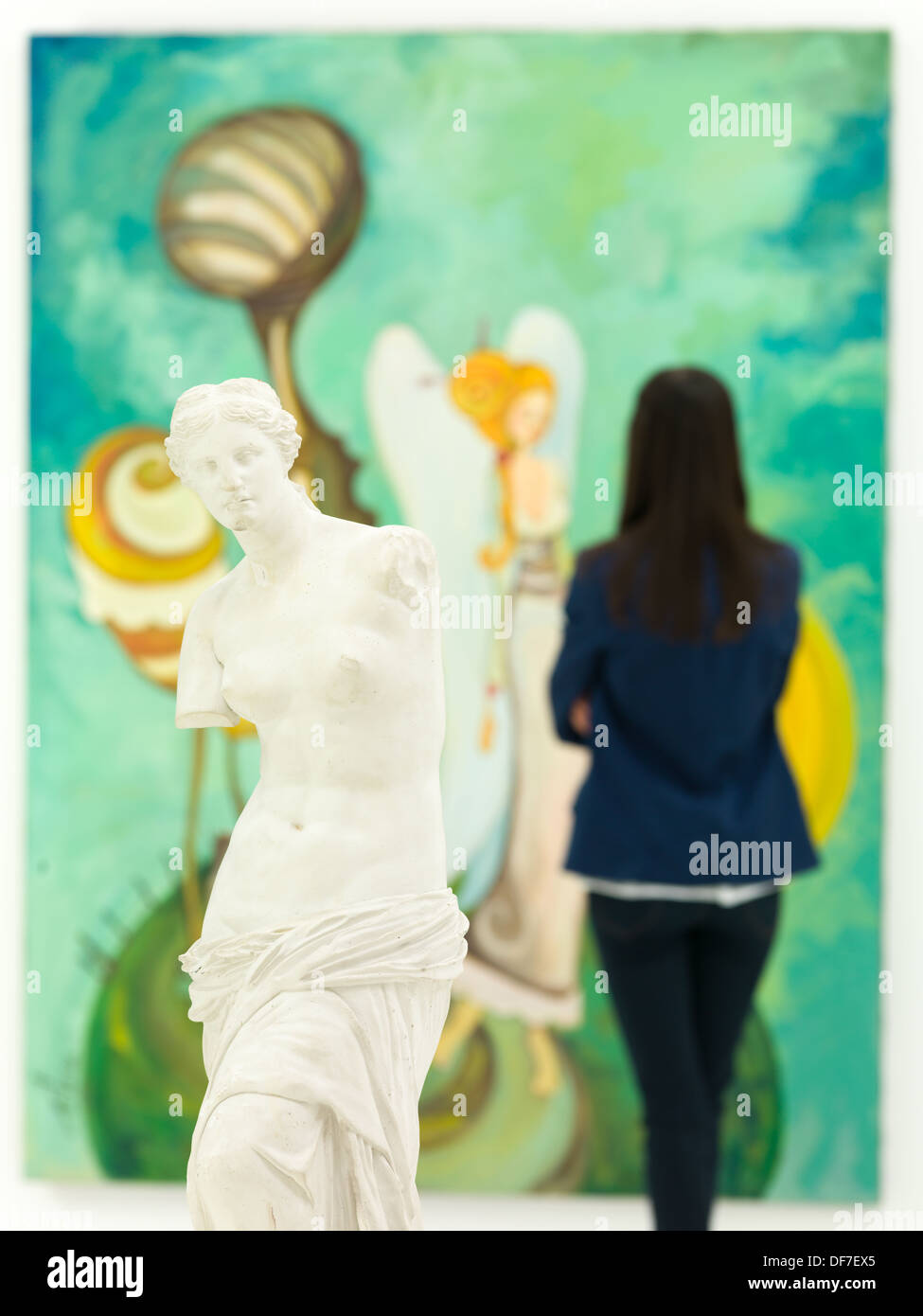 Mujer mirando su colorido gran pintura detrás de una réplica de la estatua  de la Venus de Milo Fotografía de stock - Alamy