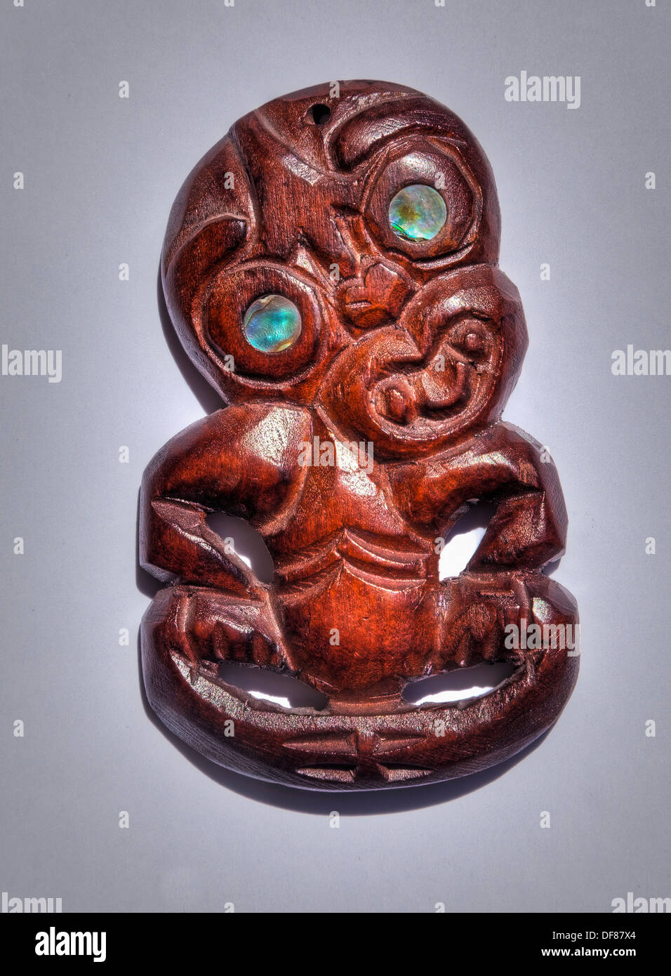 Tiki tallada en madera con Concha Paua ojos, maoríes buena suerte y símbolo de la fertilidad Foto de stock