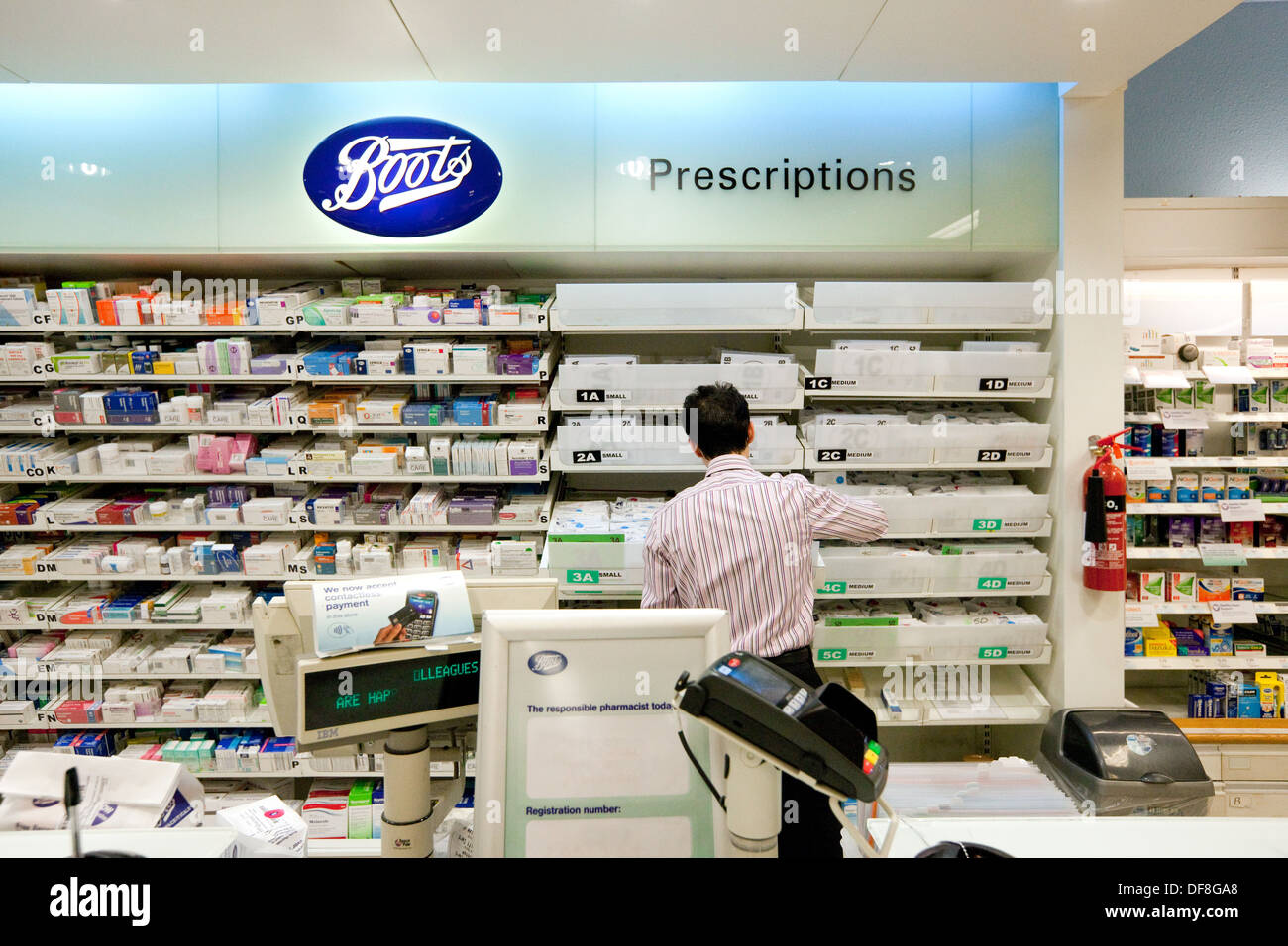 Mostrador de farmacia; interior de farmacia del Reino Unido; Boots the Chemist, el farmacéutico que trabaja en la farmacia, Reino Unido Foto de stock